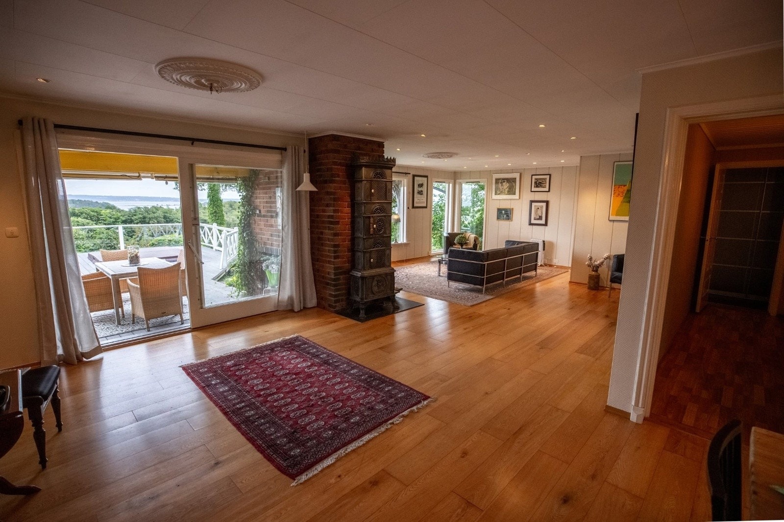 Vi fortsetter inn i boligens romslige stue med parkettgulv Galleribilde