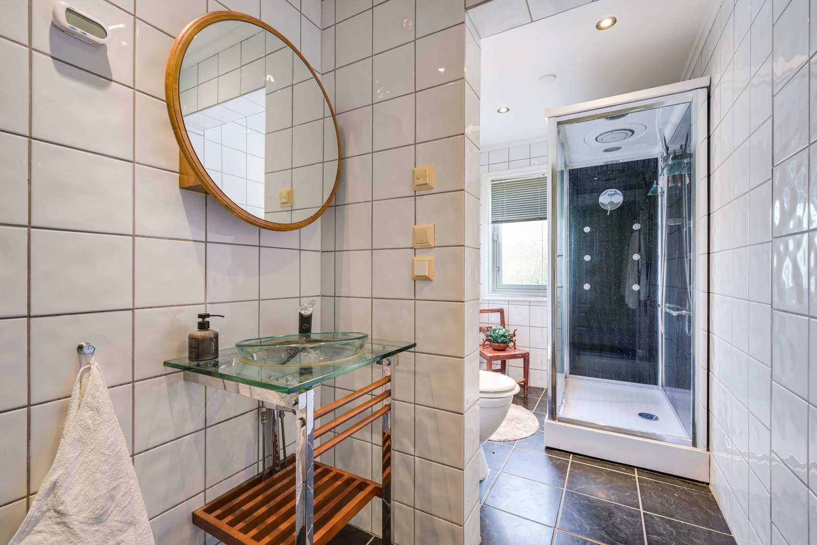 Romslig og flislagt bad i tiknytning til hovedsoverommet Galleribilde