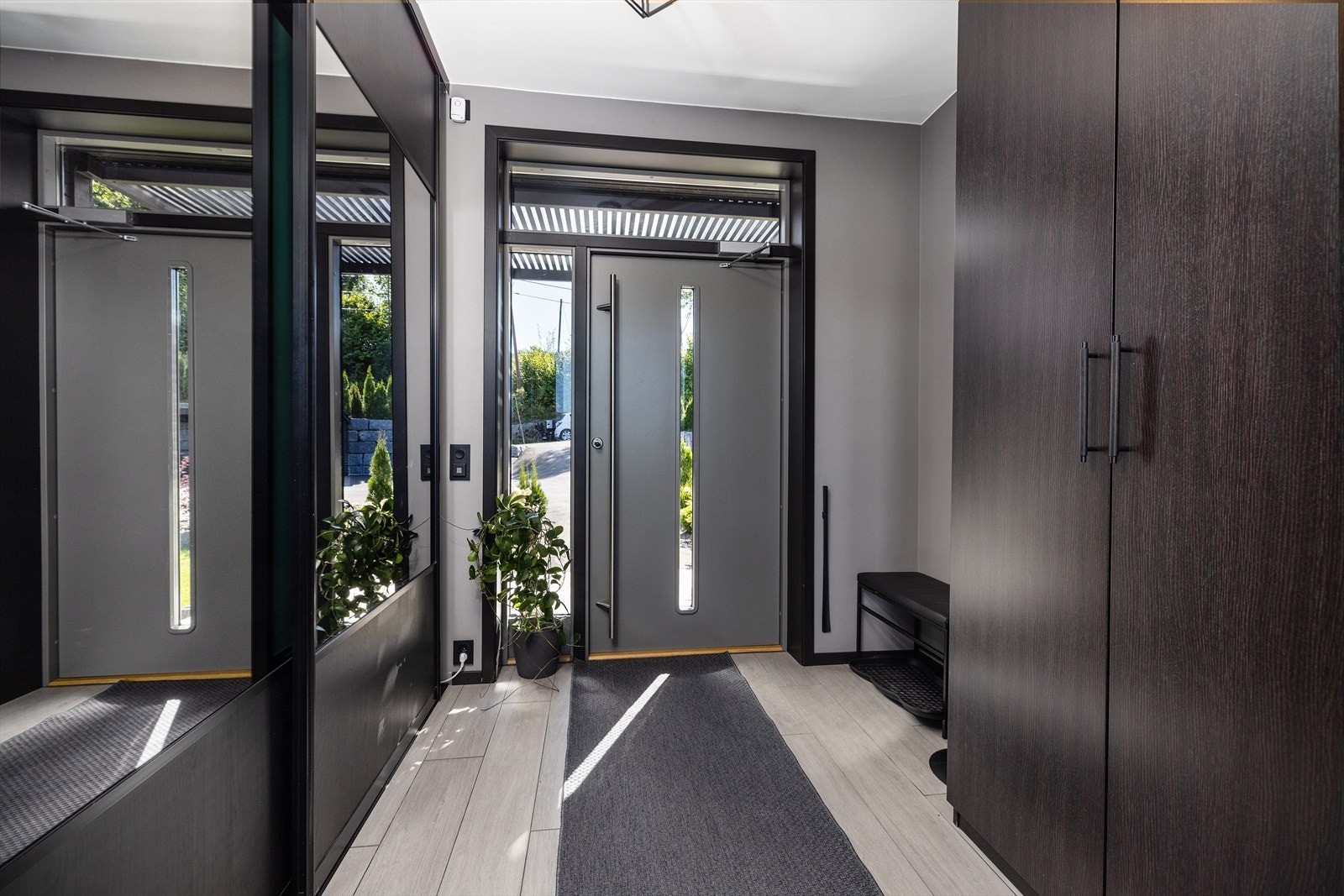 Lys og innbydende entré med god plass til oppbevaring av klær og sko i skyvedørsgarderobe og garderobeskap. Galleribilde