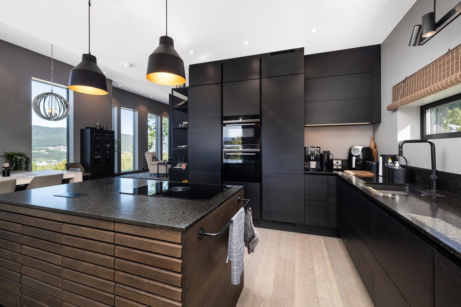 Elegant og tidløs kjøkkeninnredning fra kvalitetsprodusenten Svanekjøkkenet med slette fronter i en mørk utførelse og benkeplate av stein. Galleribilde