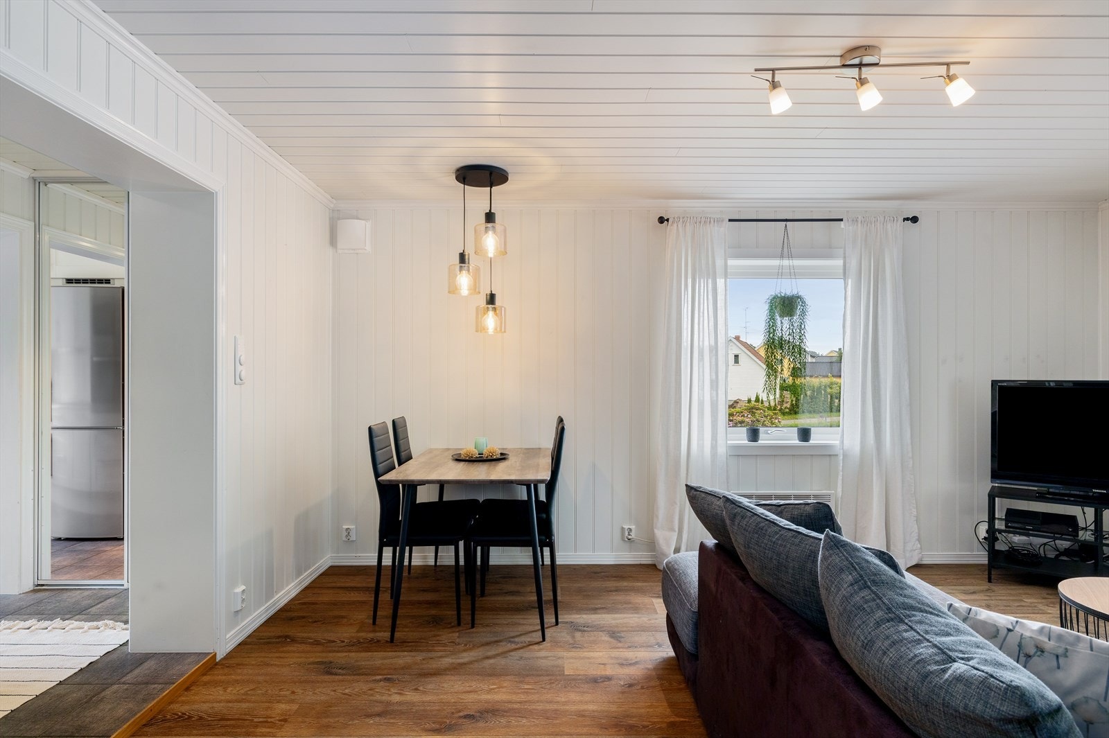 I ytterkant av stuen finner du en hyggelig og praktisk spiseplass, perfekt plassert nær kjøkkenet for enkel servering og gode måltider. Galleribilde