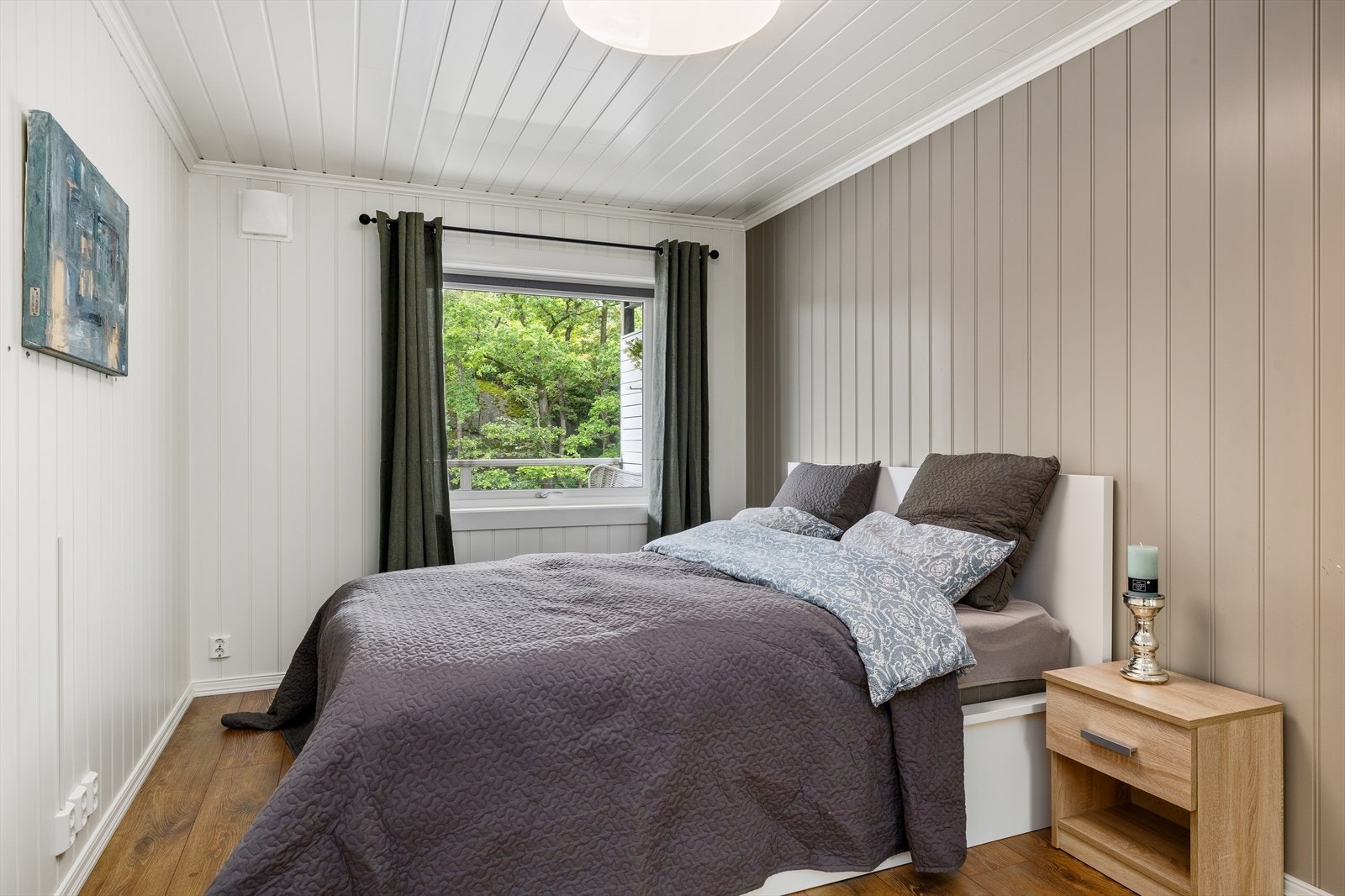 Delikat og romslig soverom med behagelige farger og en moderne kontrastvegg som tilfører både dybde og stil. Galleribilde