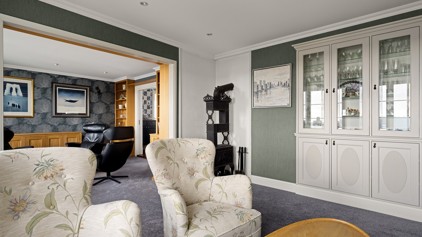 Fine detaljer med godt gjennomtenkt belysning, tapet på vegg, vegg til vegg teppe på gulv og plassbygd vitrineskap Galleribilde