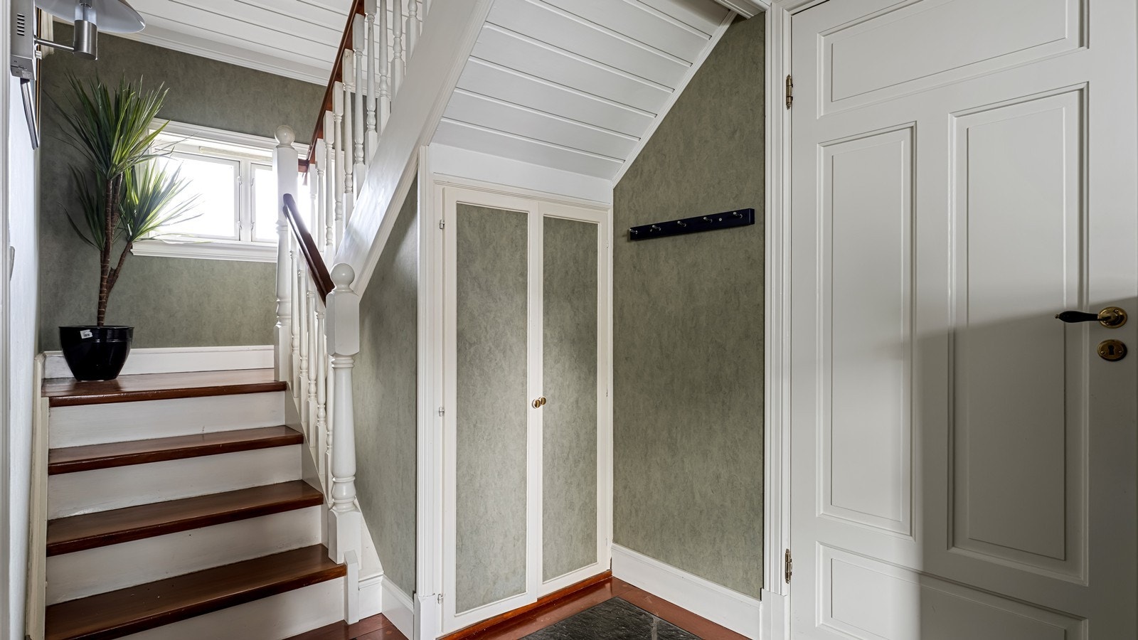 Pen hall i flotte farger. Rett foran skapdørene er det et område på gulvet uten varmekabler hvis man vil åpne trappeløp Galleribilde