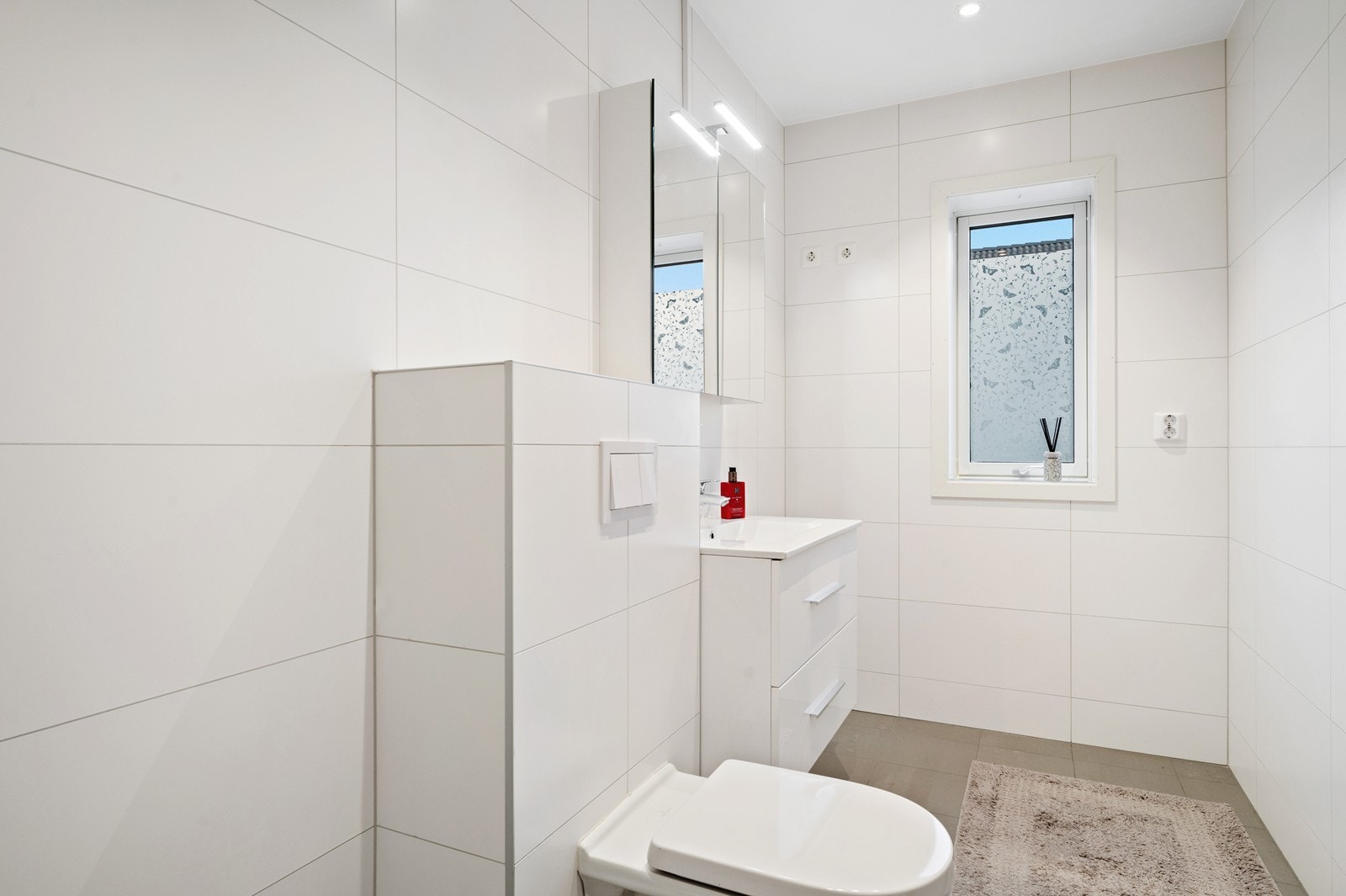 Badet har et stilrent og tidløst uttrykk med fliser både på vegger og gulv Galleribilde