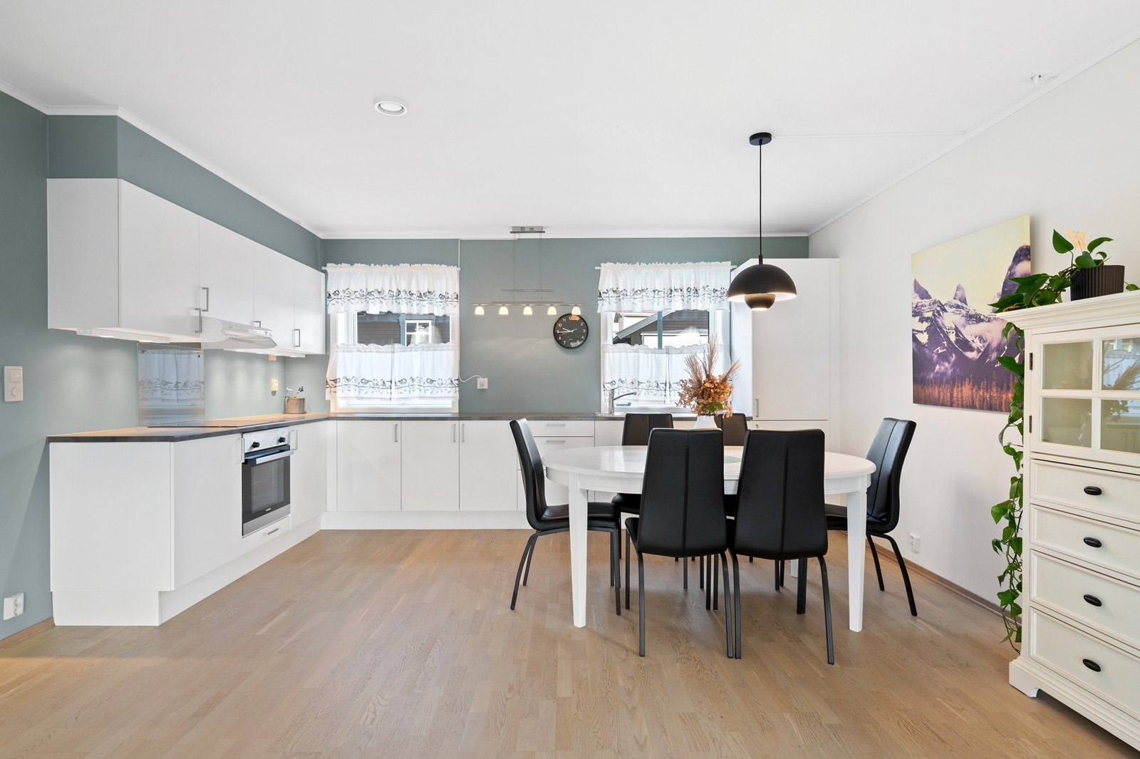 Kjøkkenet har en lys og åpen og løsning mot stuen, med moderne fabrikklakkerte fronter og laminat benkeplate. Galleribilde