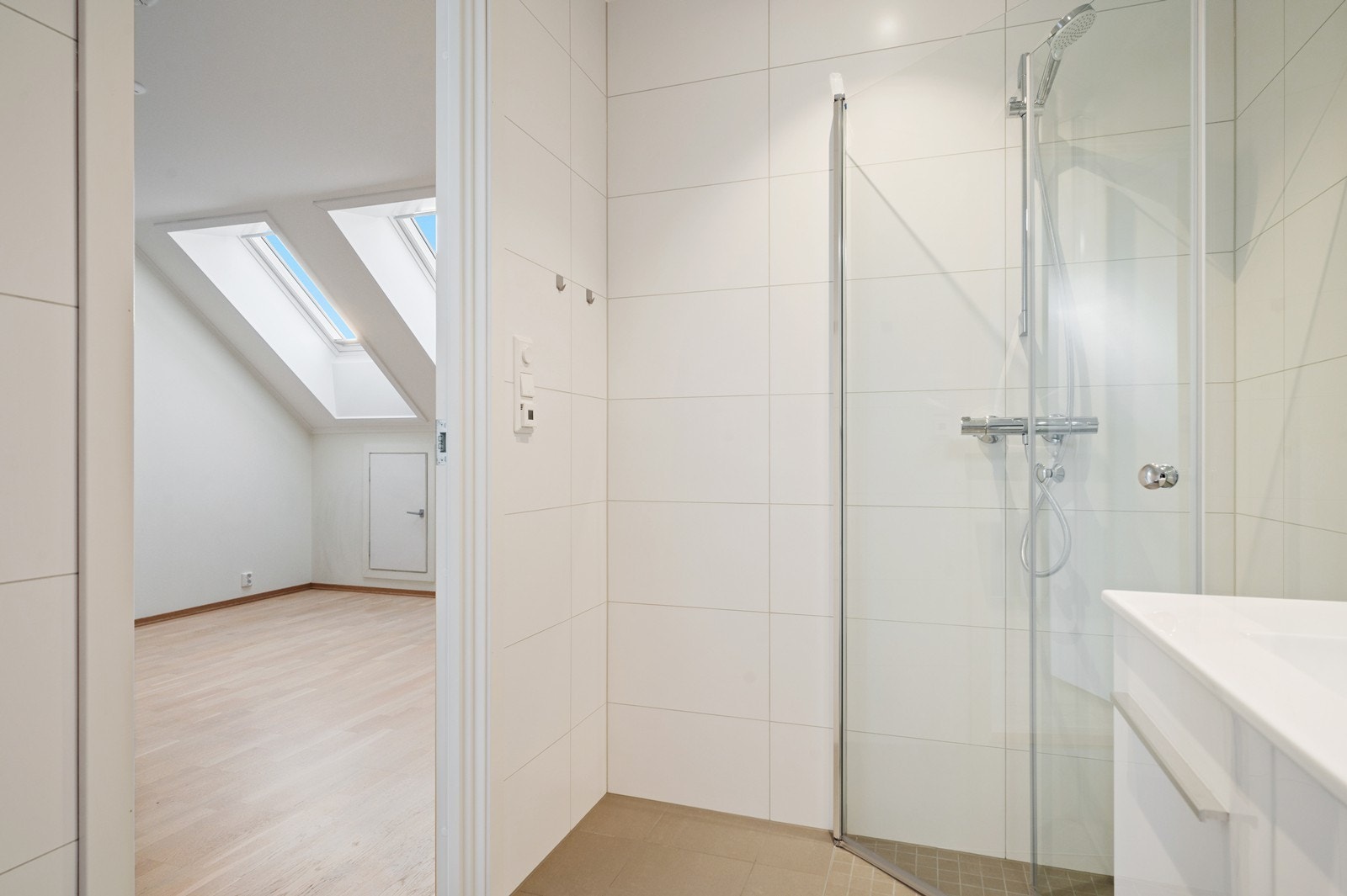 Rommet har innredning med nedfelt servant, veggmontert toalett og dusjvegger/hjørne Galleribilde