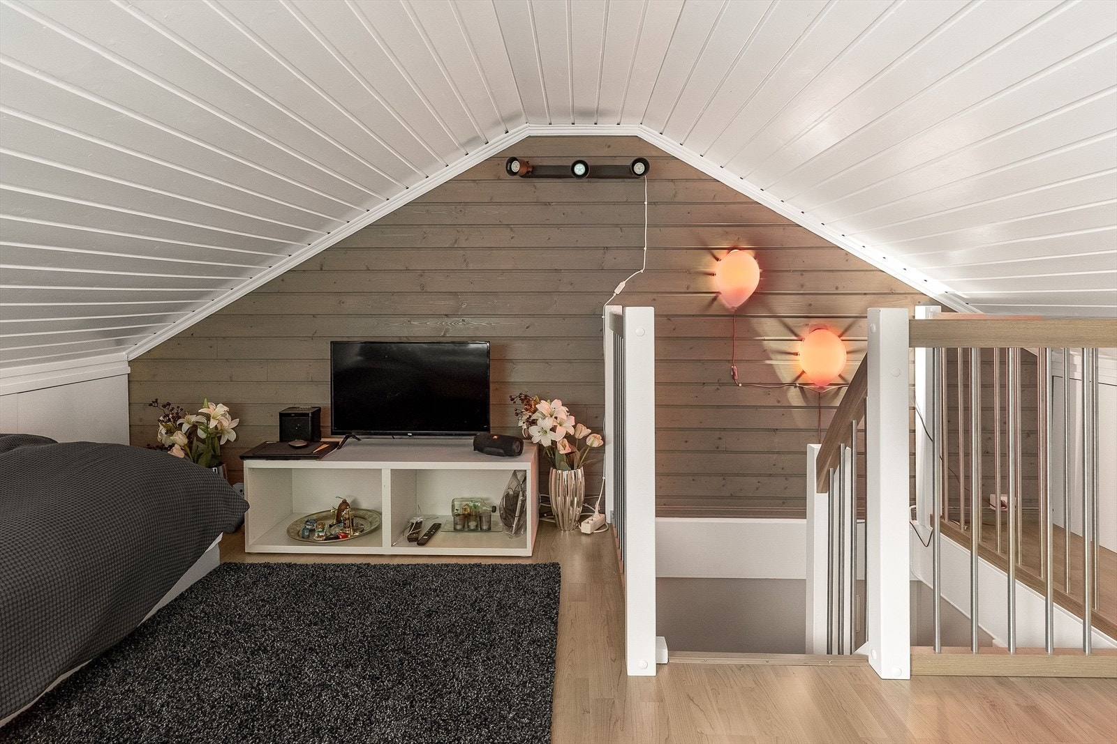 Rommet har skråtak, fine takvinduer, laminat på gulv og for øvrig panelte overflater. Her er det god plass for sofa og tv-løsning. Galleribilde