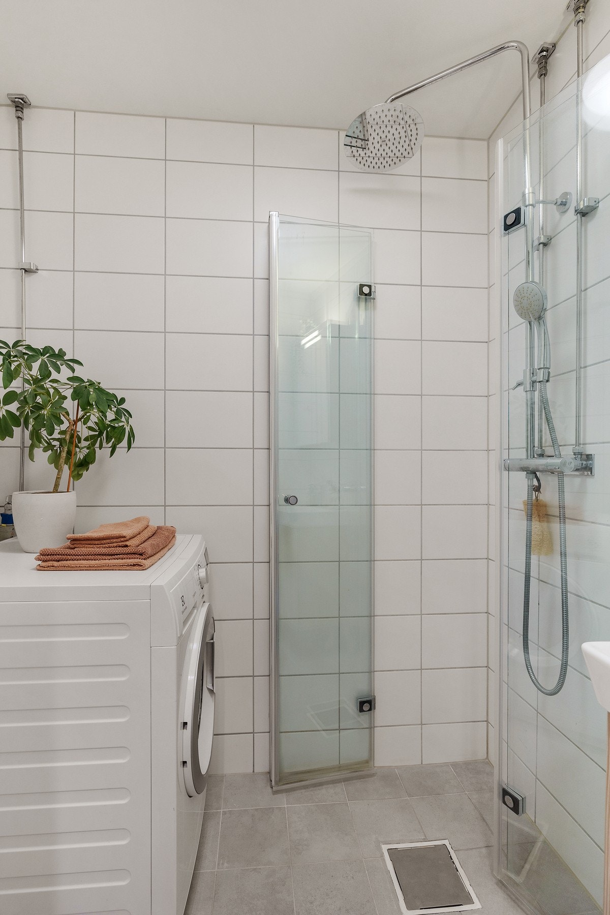 Praktisk servantinnredning, speilskap, vegghengt toalett, dusj med glassdører og opplegg for vaskemaskin. Galleribilde
