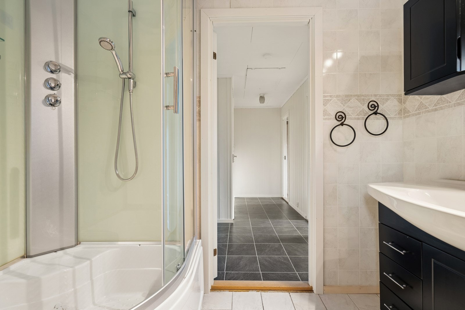 Baderommet er innredet med dusjkabinett og servant med skapinnredning. Galleribilde