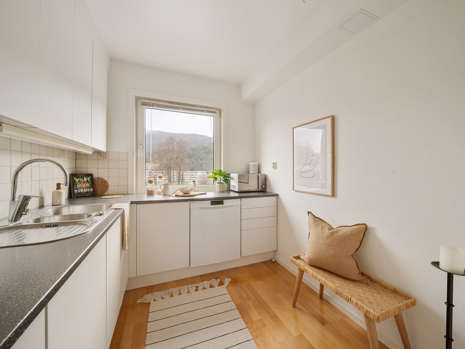 Kjøkkenet er romslig, lyst og funksjonelt, med en moderne innredning som har glatte, hvite fronter (oppgradert 2024/25) og laminat benkeplate Galleribilde