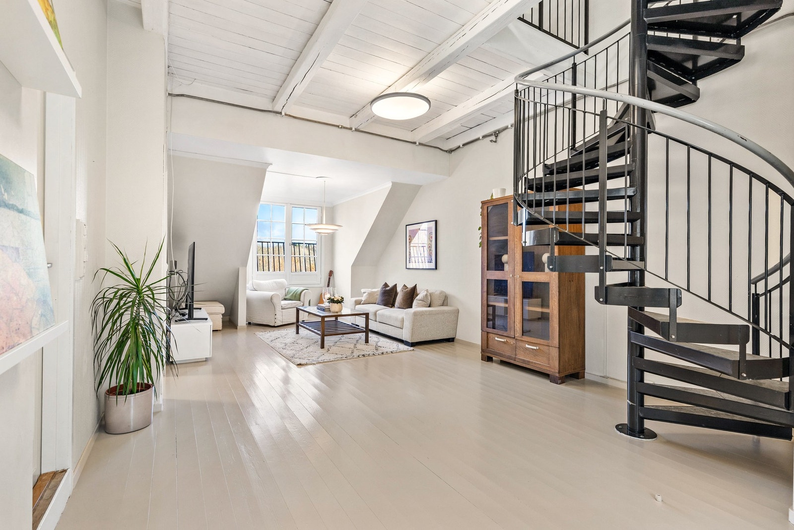 Gjennomgående stue med malt furugulv, malte strievegger og malt trepanel i himling Galleribilde