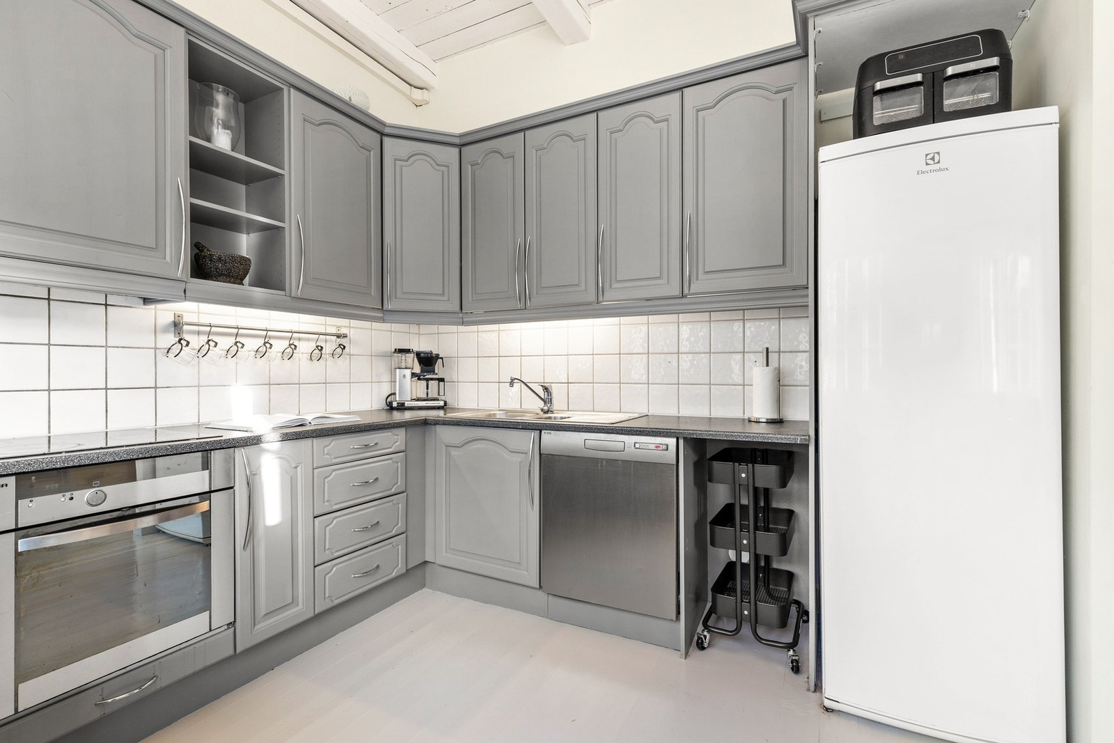 Det er også plass til frittstående kjøleskap og kjøkkenventilator med kullfilter er montert over platetopp Galleribilde