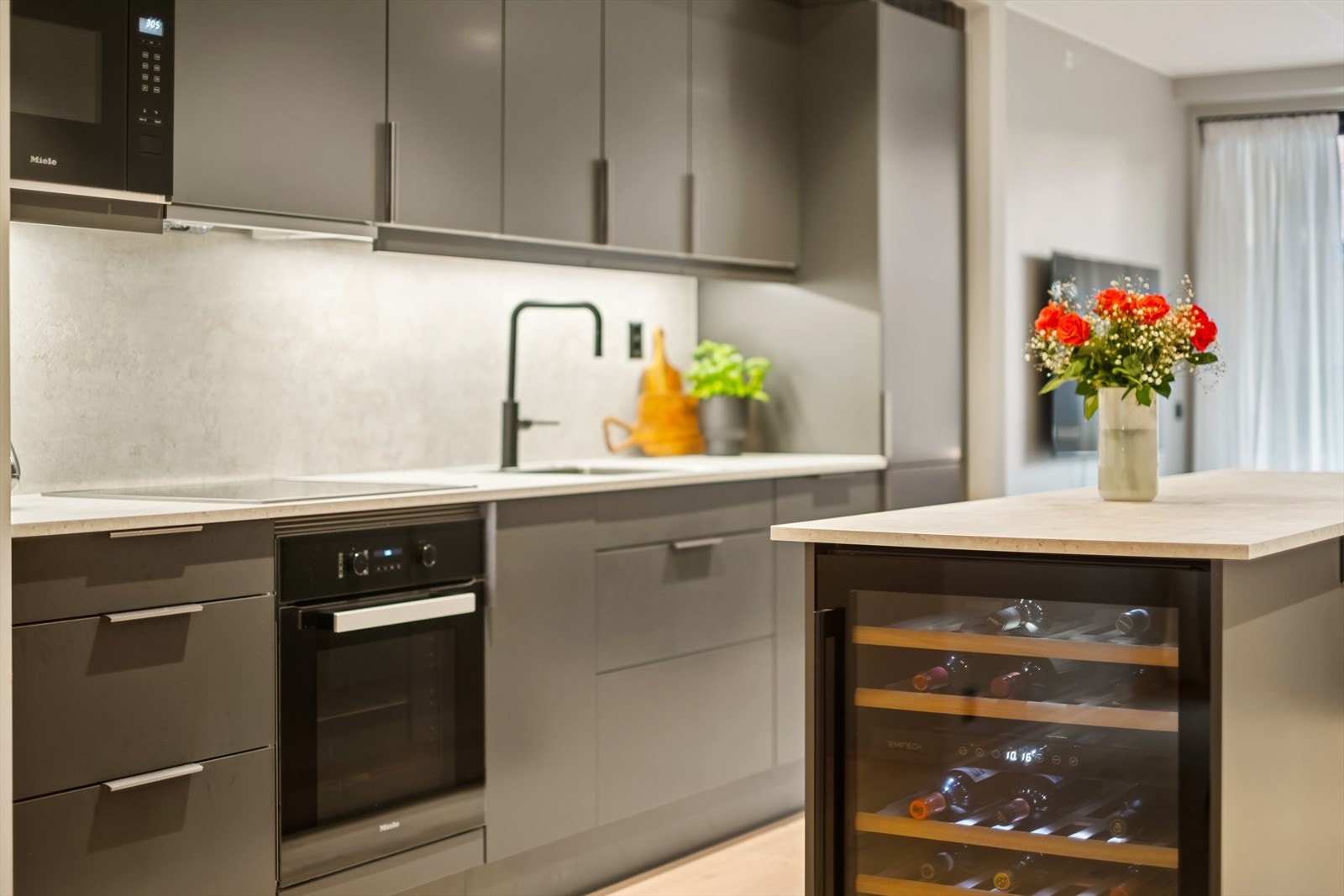 Moderne kjøkken fra Sigdal med mørke slette fronter, laminert benkeplate og oppvaskkum. Galleribilde