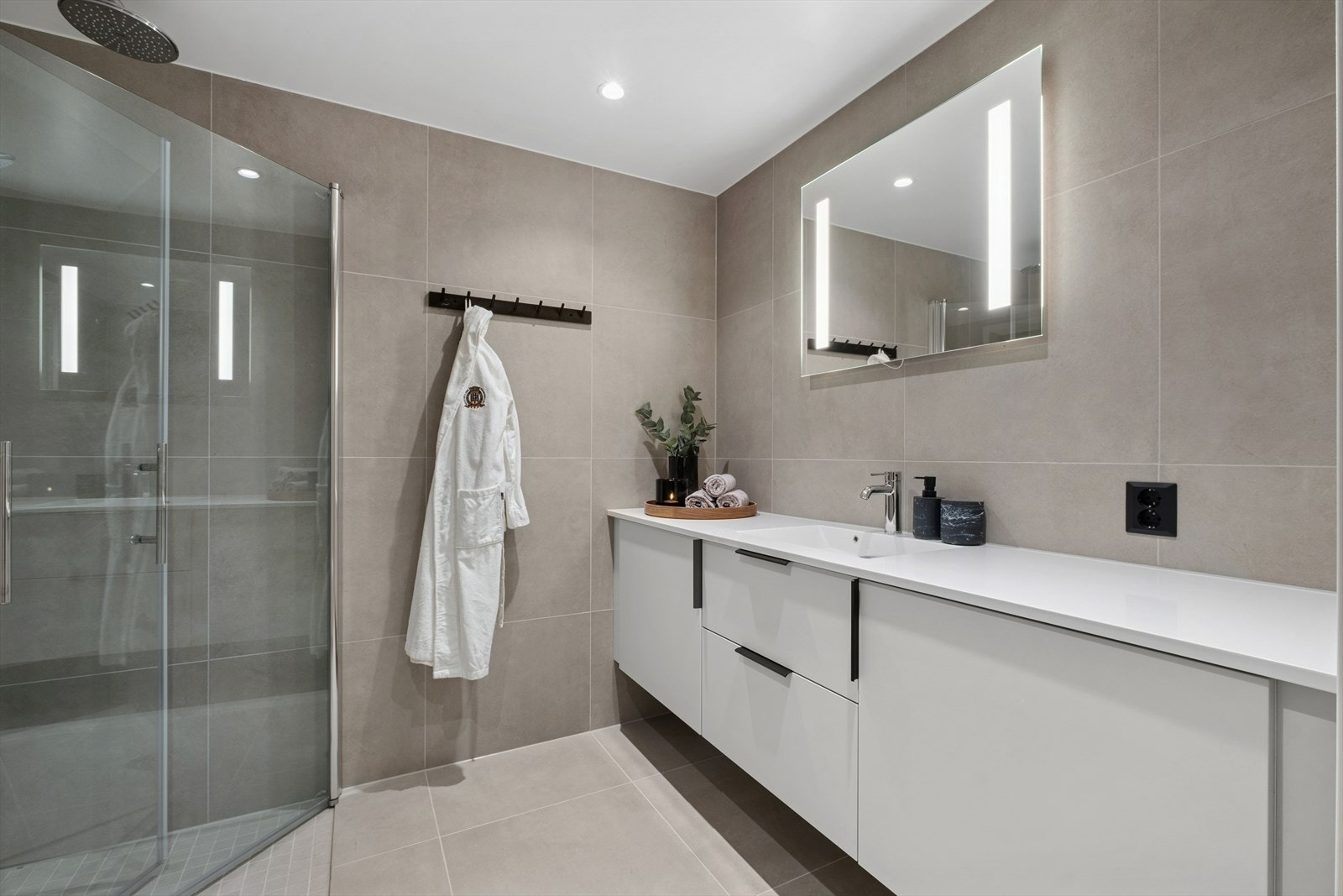 Baderommet har flislagte gulv og vegger, i fin fargetone. Galleribilde