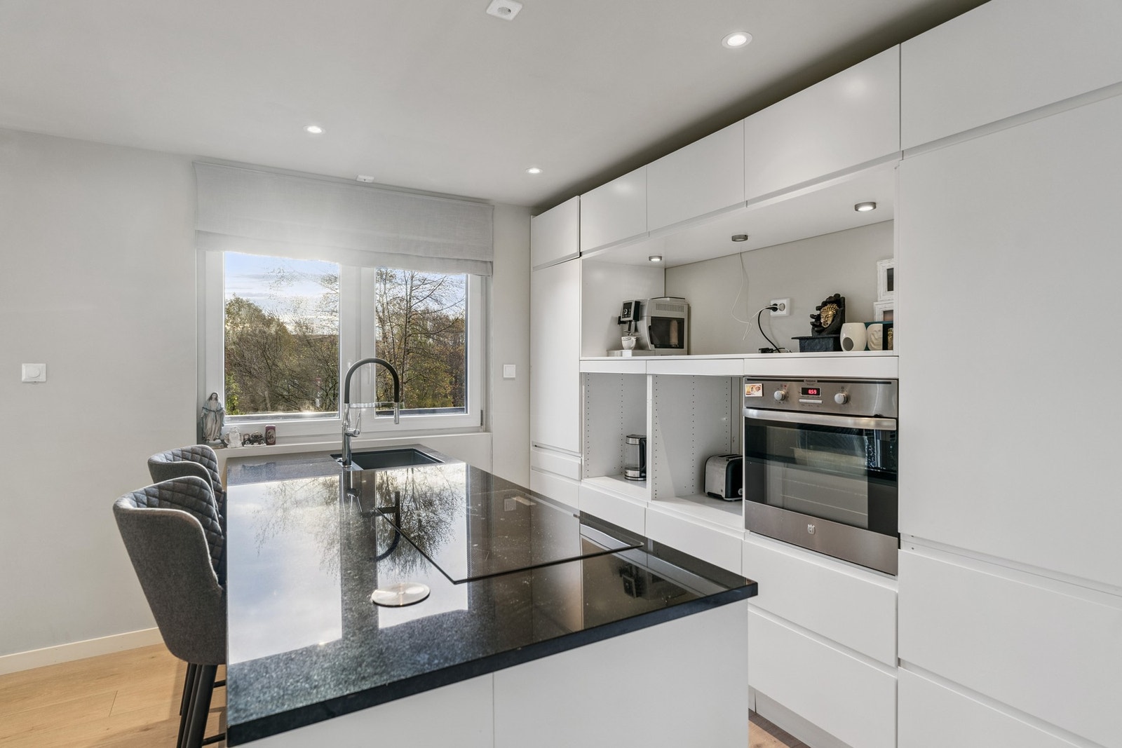 Det er integrerte hvitevarer som stekeovn, induksjonstopp oppvaskmaskin og kjøl/fryseskap Galleribilde