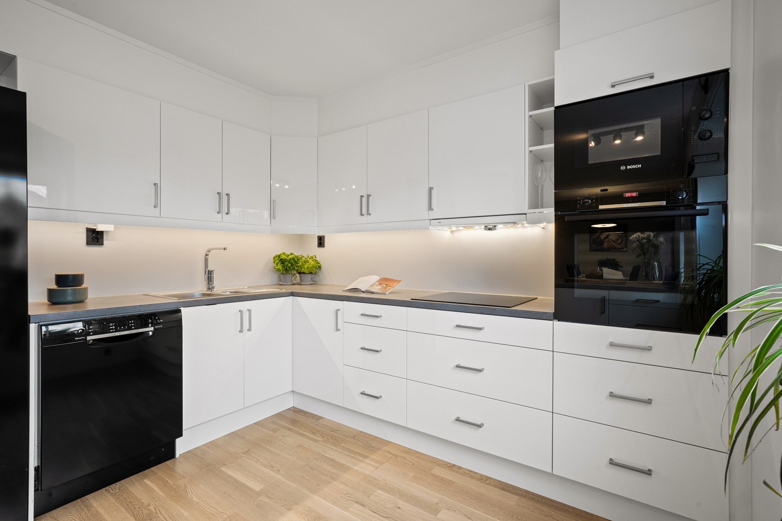 Moderne kjøkken fra byggeår med hvite, slette fronter og laminat benkeplate. Galleribilde