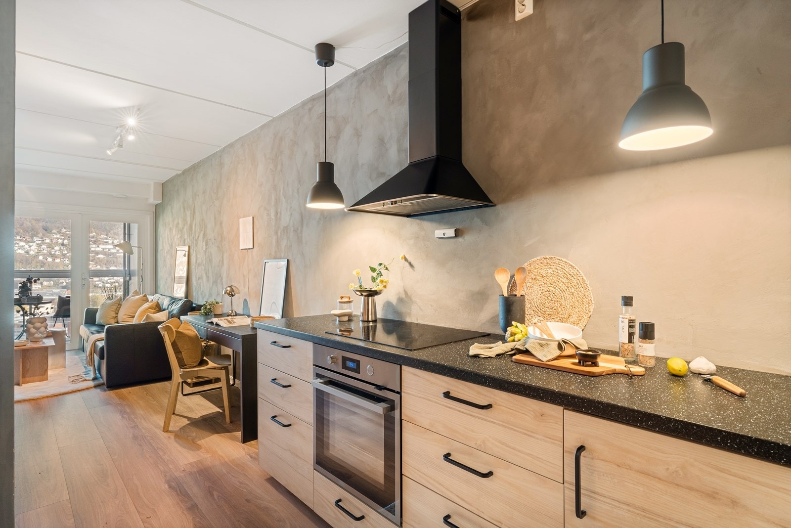 Stilrent kjøkken fra 2020 med finerte fronter og mørk laminat benkeplate. Galleribilde