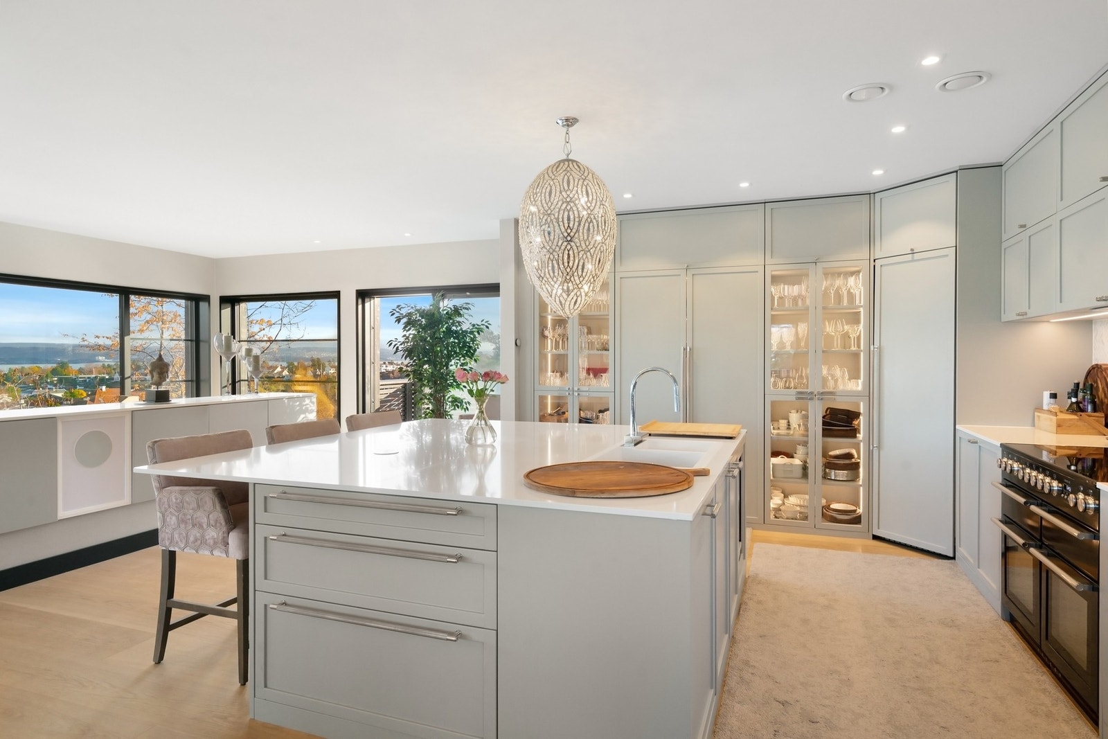 Kjøkkenet har stor innredning og kjøkkenøy med malte eikefronter og brede skuffer, glasskap og overskap. Stort dobbeltskap med innfellbare dører som har kaffemaskin og anretning. Galleribilde