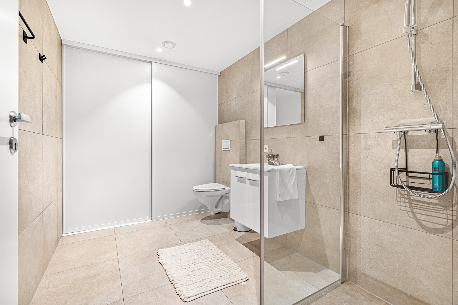 Lekker bad med opplegg for vaskemaskin og tørketrommel bak skyvedørene. Galleribilde