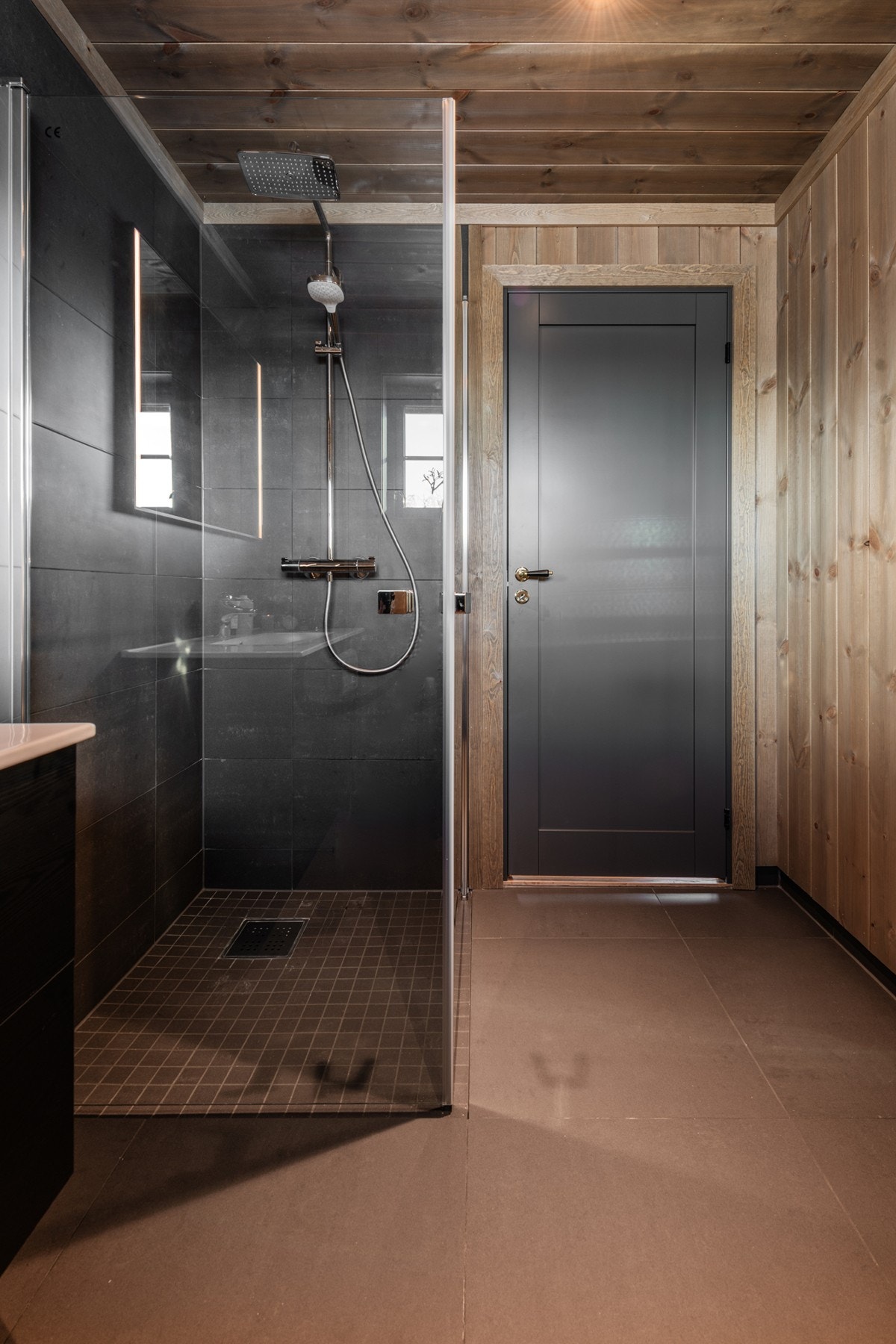 Det er lagt flotte, grå flier på gulvet og panel på vegger og i himling. Galleribilde