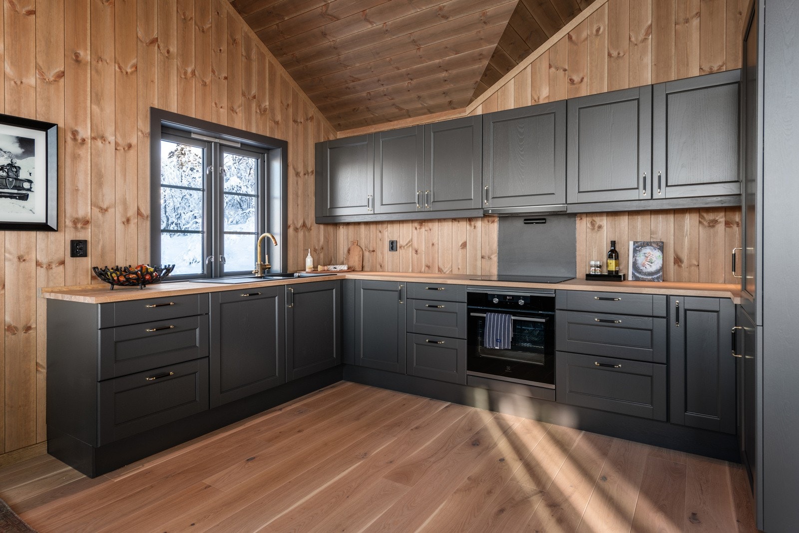 Innredningen har malte skrog og fronter og heltre benkeplate med nedfelt oppvaskku Galleribilde