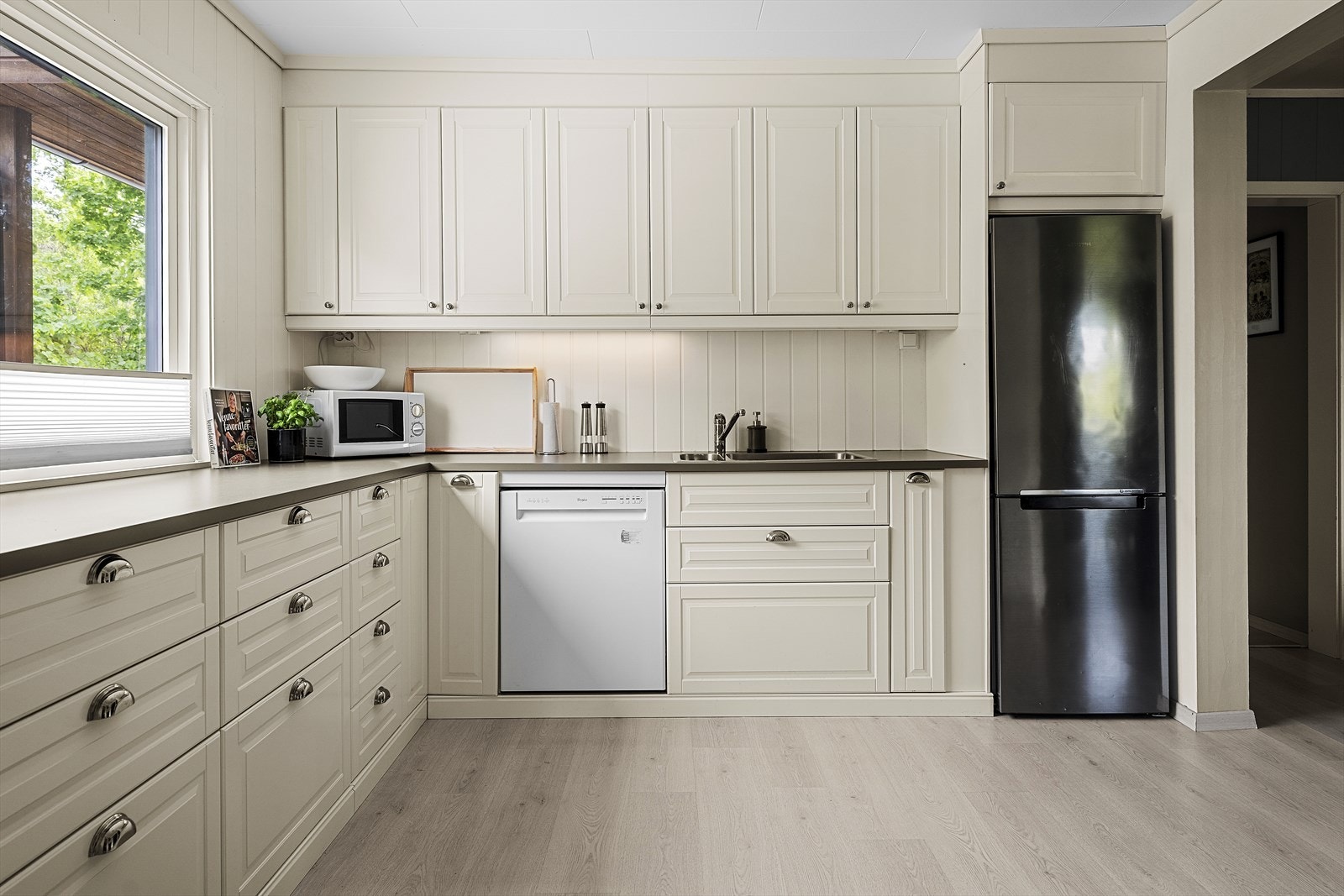 Kjøkkeninnredning med hvite, profilerte fronter og laminert benkeplate Galleribilde