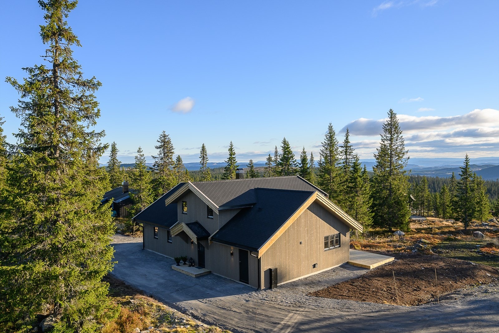 Solrik, forholdsvis flat tomt med gruset adkomst. Galleribilde