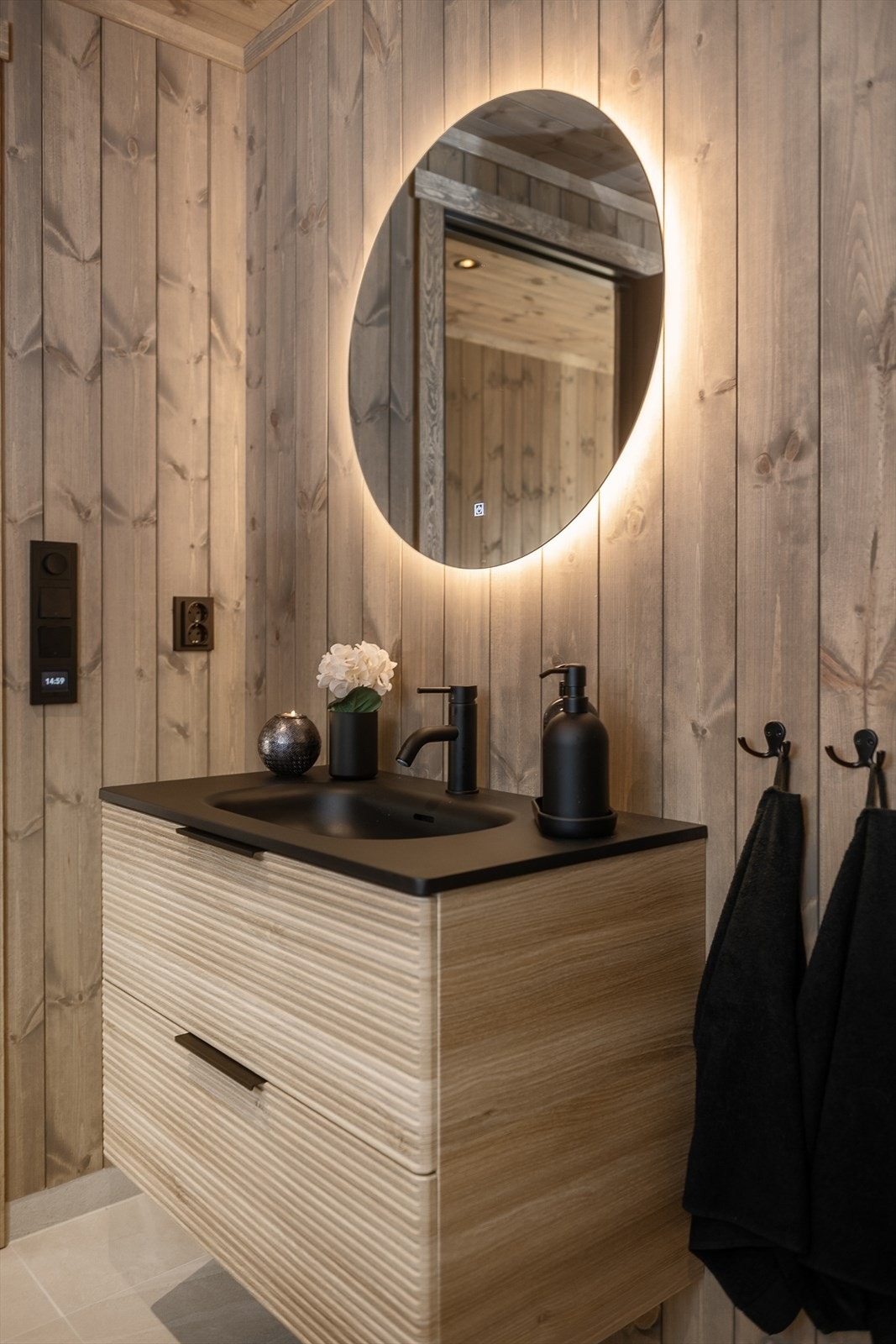 Baderomsmøbel fra Lind. Innredning med skuffer og oppbevaring. Lyssatt speil over servant med antidogg. Galleribilde