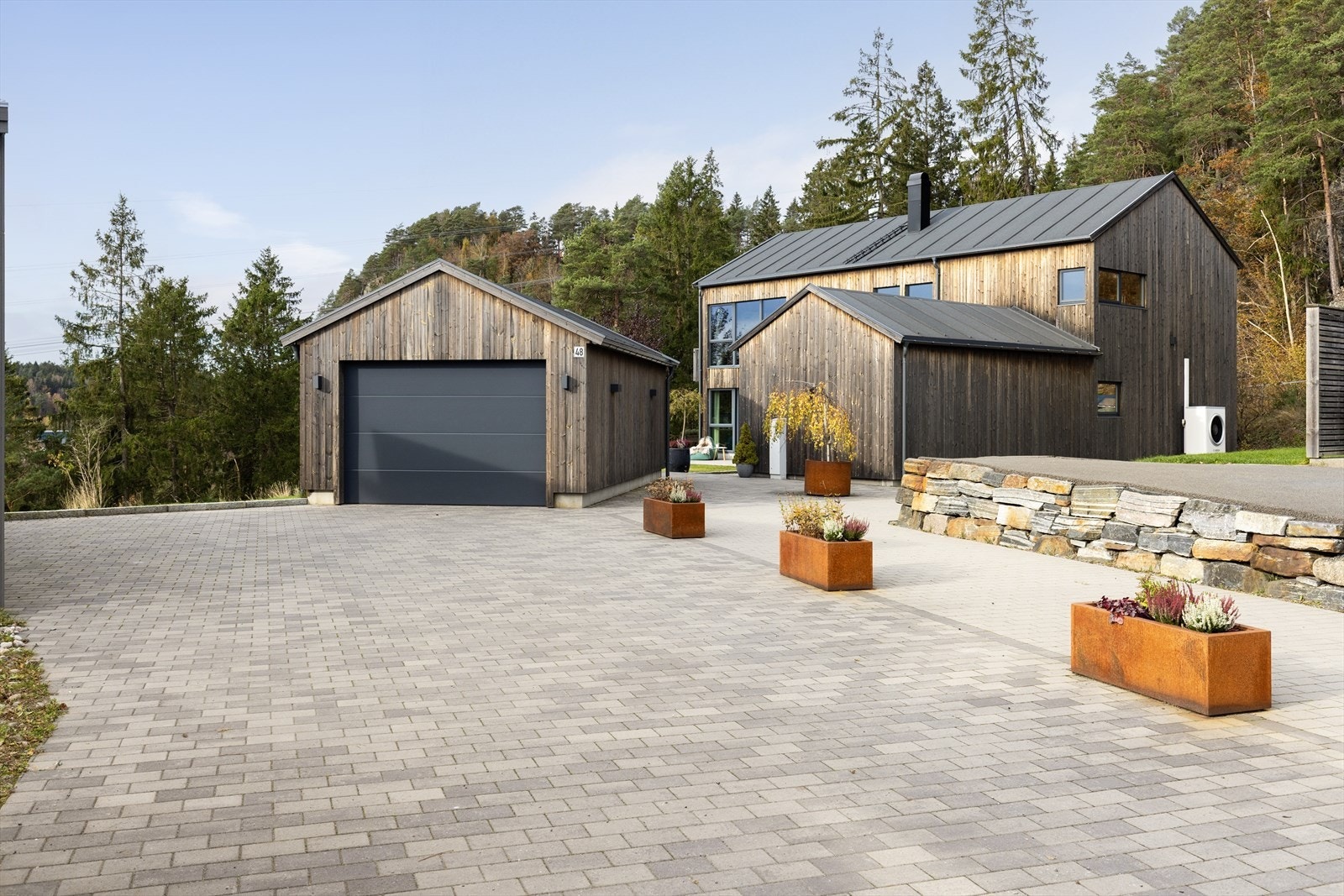 Romslig og pent opparbeidet tomt med skjermet og lettstelt hage, flotte terrasseområder og frittstående garasje med elbil-lader. Galleribilde