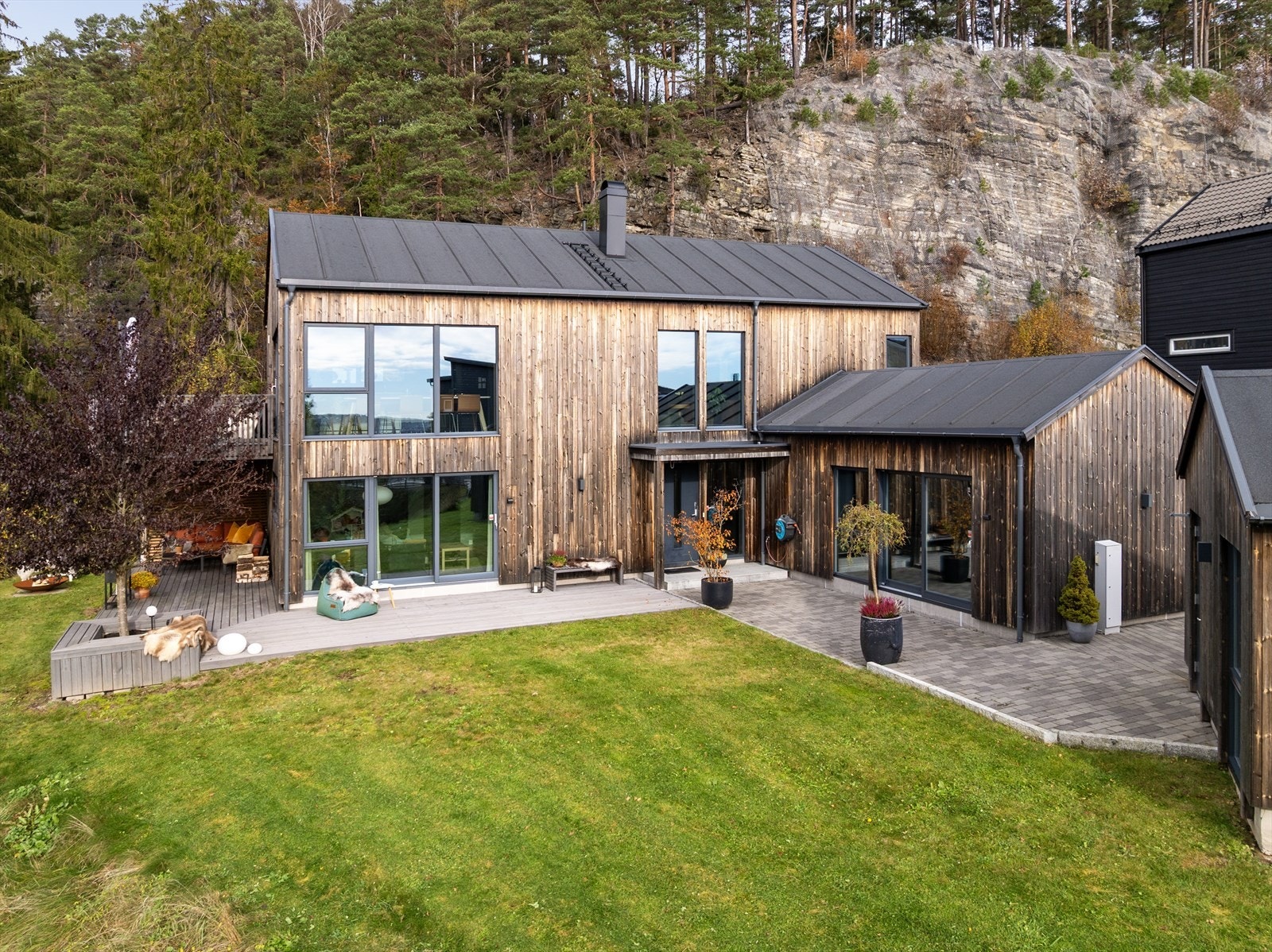 Utvendig har boligen en moderne og stilren fasade, med stående kledning av malmfuru og store vindusflater med aluminiumsbeslag og UV-filter. Galleribilde