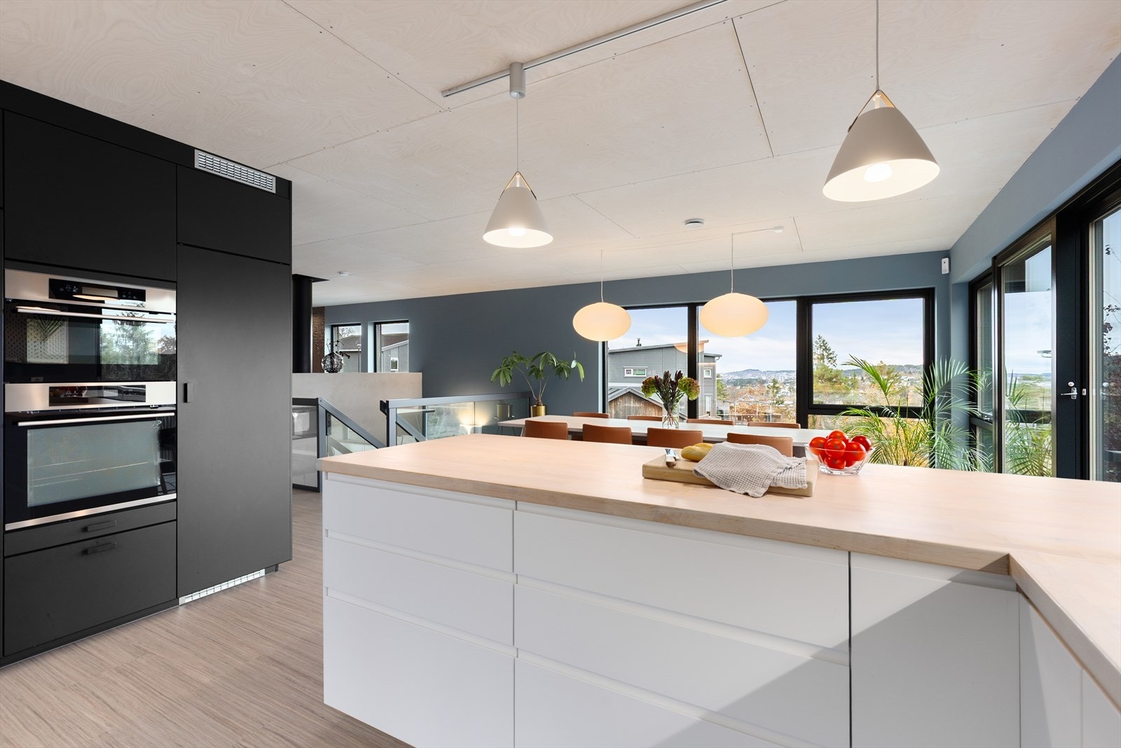 Kjøkkenventilator med avtrekk ut. Den åpne løsningen skaper et fint, sosialt samspill mellom sonene, med praktisk halvøy ut mot spisestuen. Galleribilde