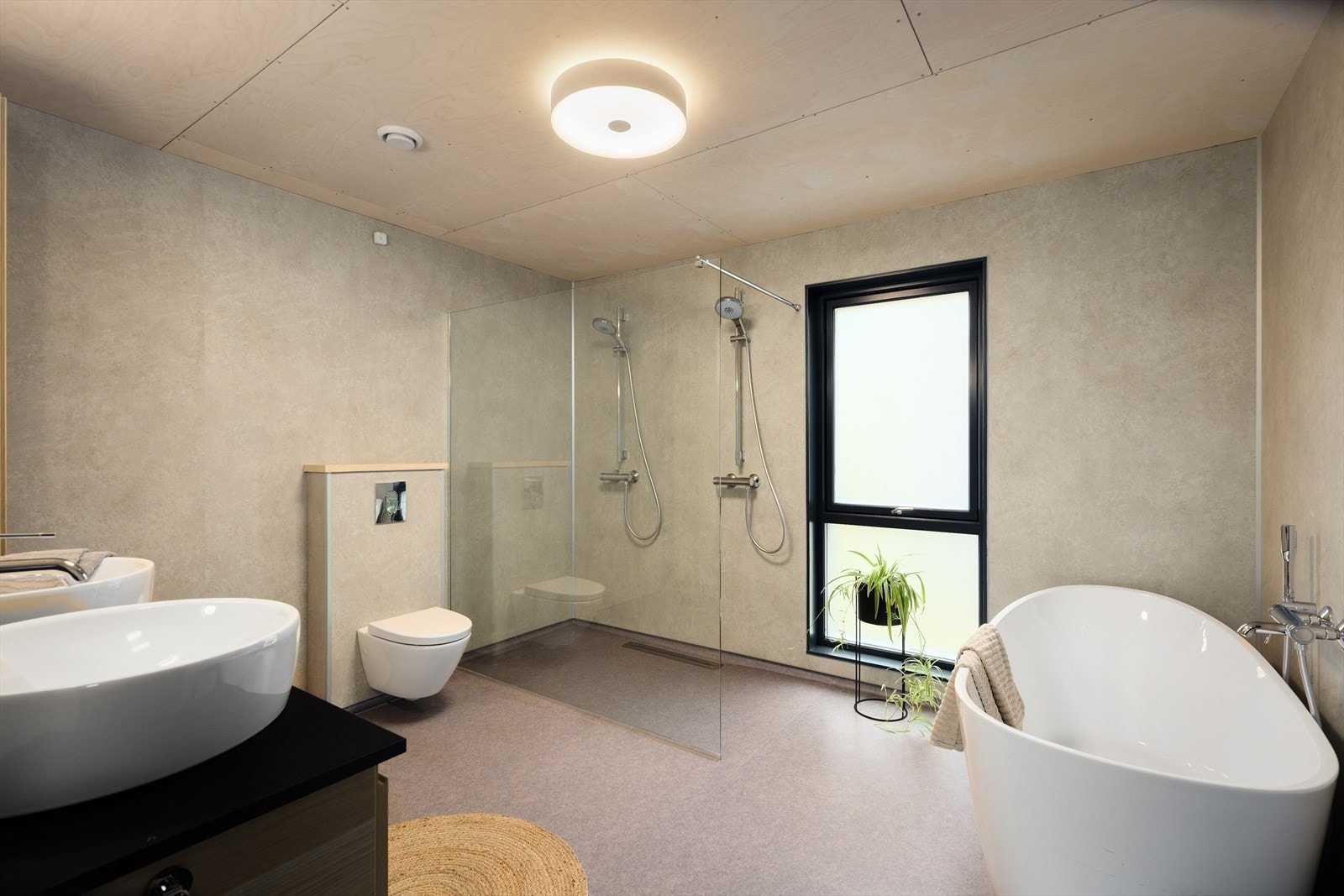 Delikat bad i 1. etasje av god størrelse. Badet har vegghengt toalett, badekar og dobbel, åpen dusjløsning avgrenset med dusjvegg i glass. Galleribilde