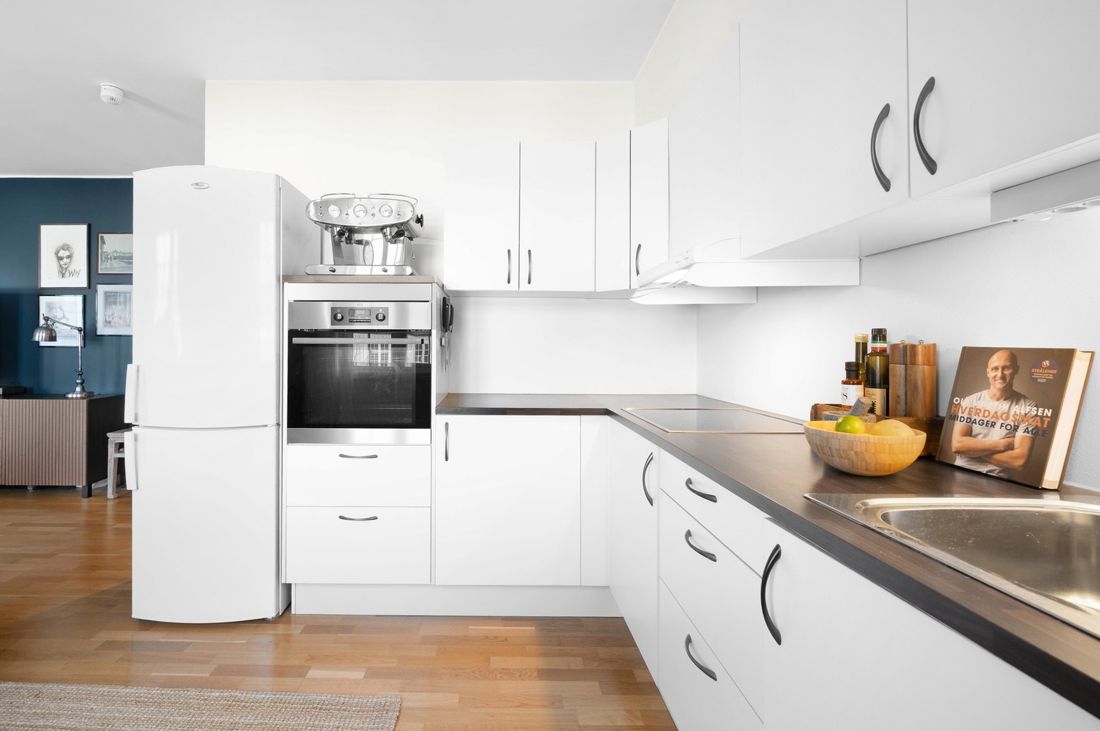 Kjøkkeninnredningen er i åpen løsning med stuen og har glatte fronter med integrert stekeovn. Frittstående kjøle/fryseskap og oppvaskmaskin.
Benkeplate i laminat med nedfelt platetopp og oppvaskkum og 1-greps blandebatteri. Galleribilde