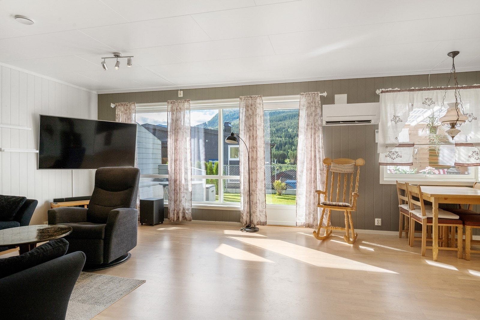 Stua er malt i lyse og tidsriktige farger og det er laminat på gulv. Galleribilde