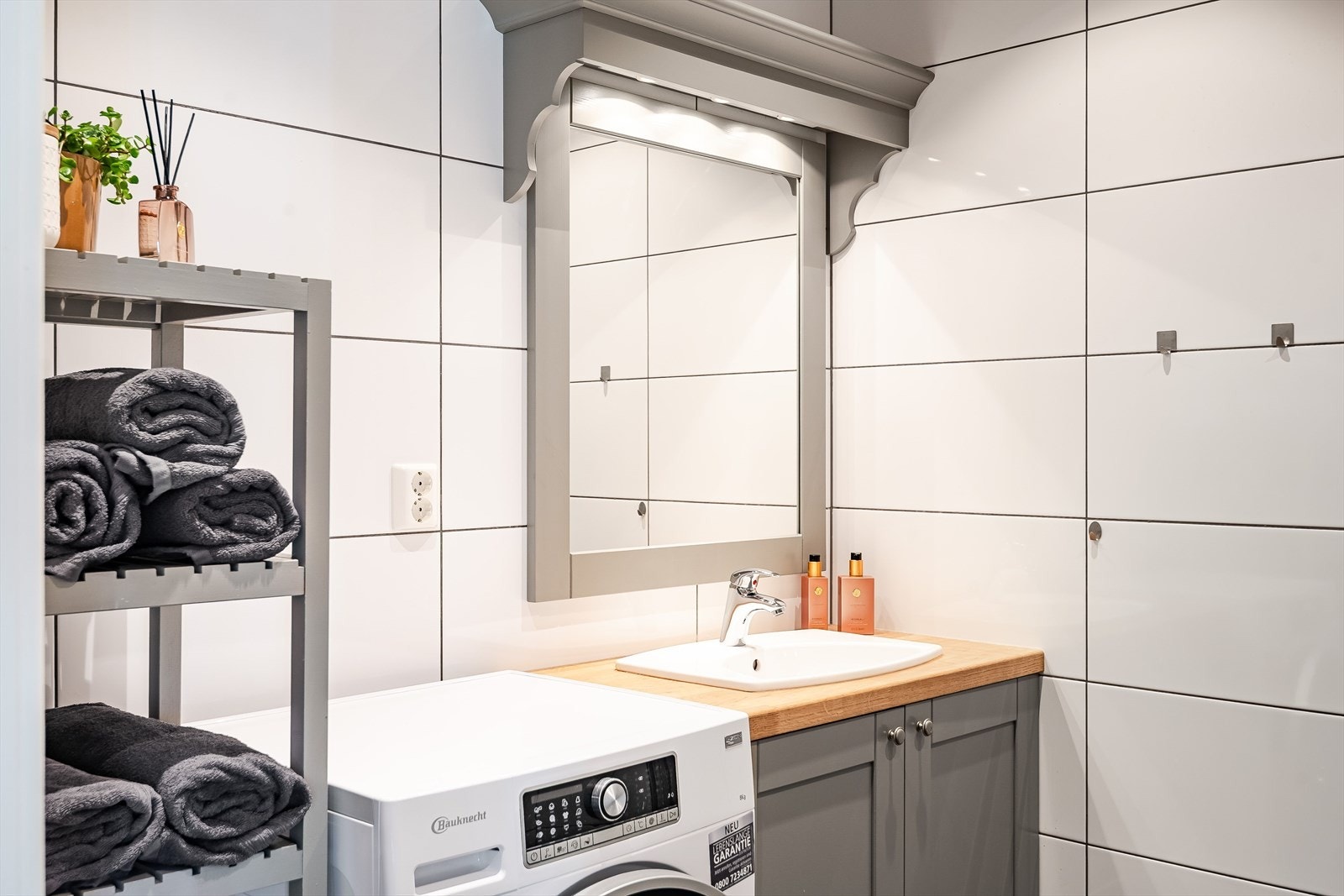 Flott baderomsinnredning med profilerte fronter og heltre benkeplate med nedfelt servant, speil med belysning over. Benkeplate er overflatebehandlet sist i 2023. Galleribilde