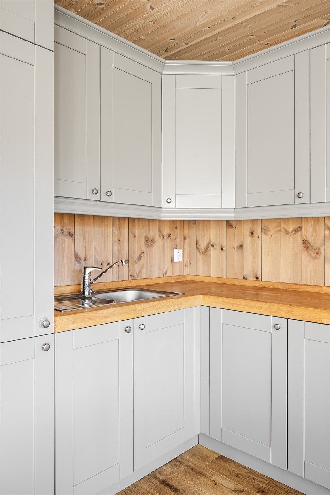 Innredningen har heltre skrog, grå profilerte fronter og heltre benkeplate med nedfelt oppvaskkum. Benkeplaten ble overflatebehandlet sist i 2023. Galleribilde