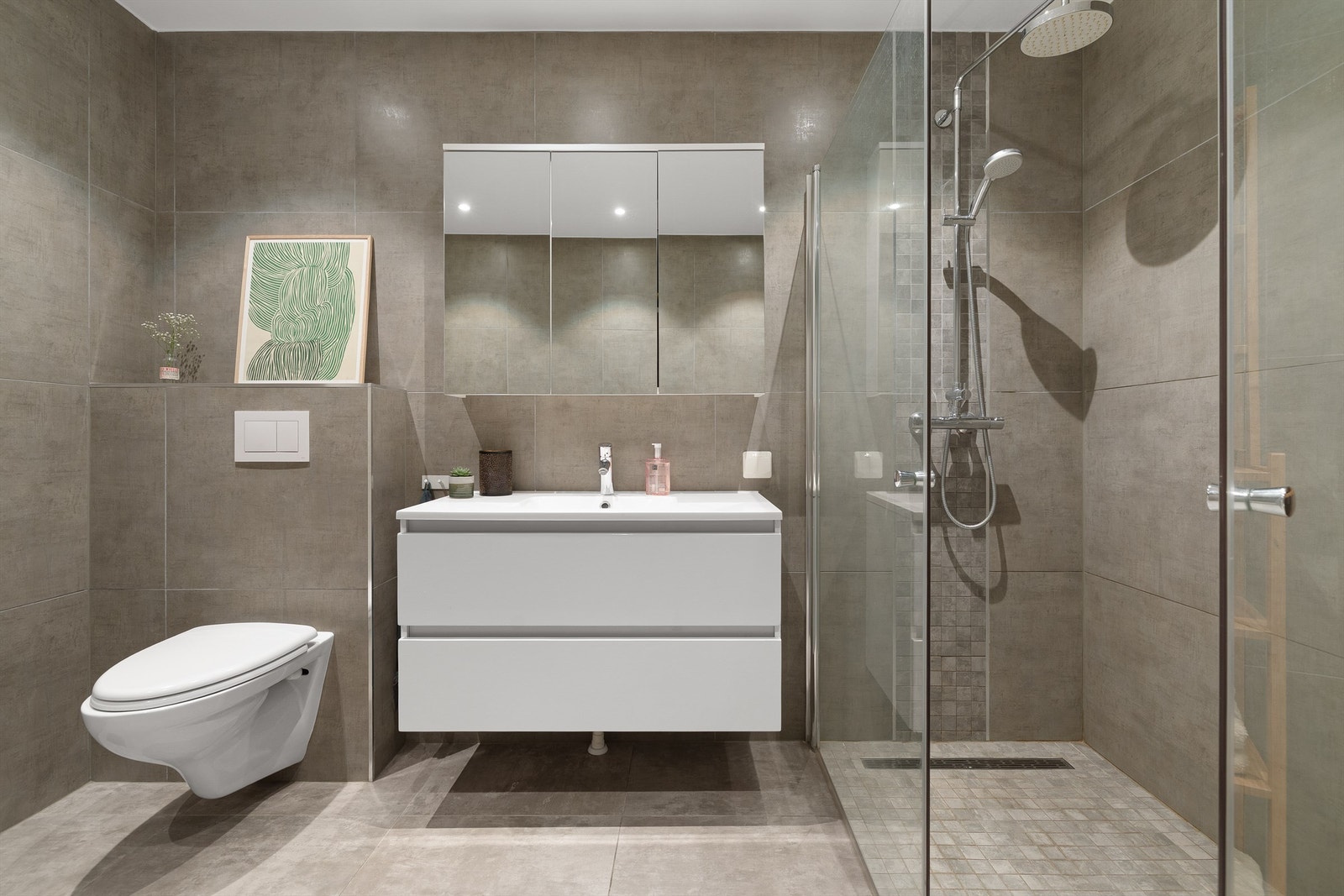 Badet er flislagt med store eksklusive fliser, varme i gulvet og downlights i himlingen samt opplegg for, og god plass til vaskemaskin og tørketrommel Galleribilde