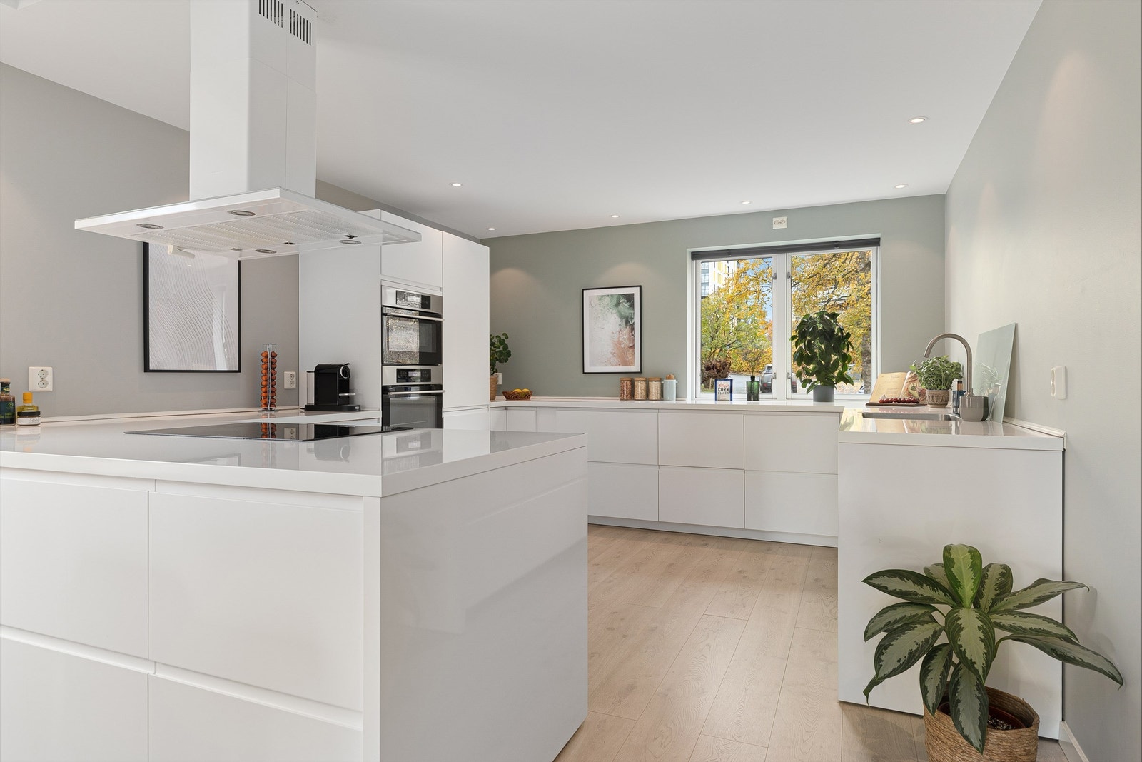 Delikat innredning fra 2017 med hvite, glatte skapfronter, benkeplater i laminat, underlimt rustfri oppvaskkum og ett-greps armatur Galleribilde