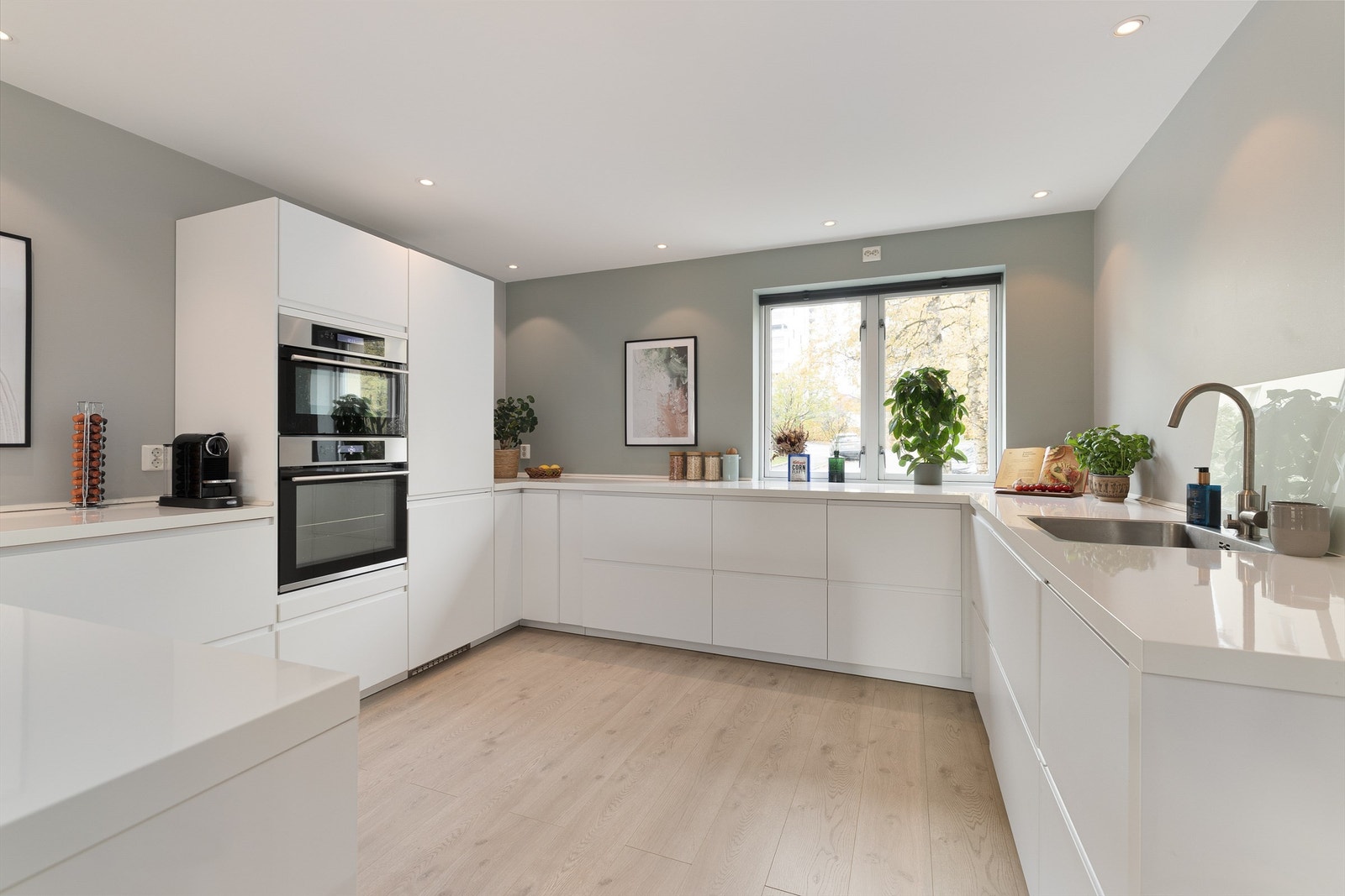 Sømløst integrerte hvitevarer som stekeovn, kombiovn, induksjon koketopp med kullfilterventilator over, oppvaskmaskin samt kjøleskap med frysedel Galleribilde