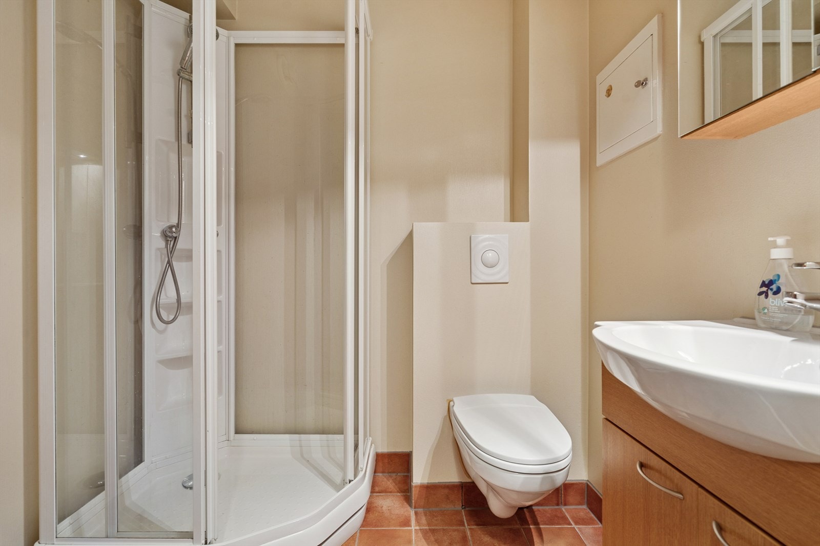 Badet er utført med flislagt gulv m/varmekabler og malte vegger - Her finner du vegghengt toalett, dusjkabinett og baderomsinnredning Galleribilde