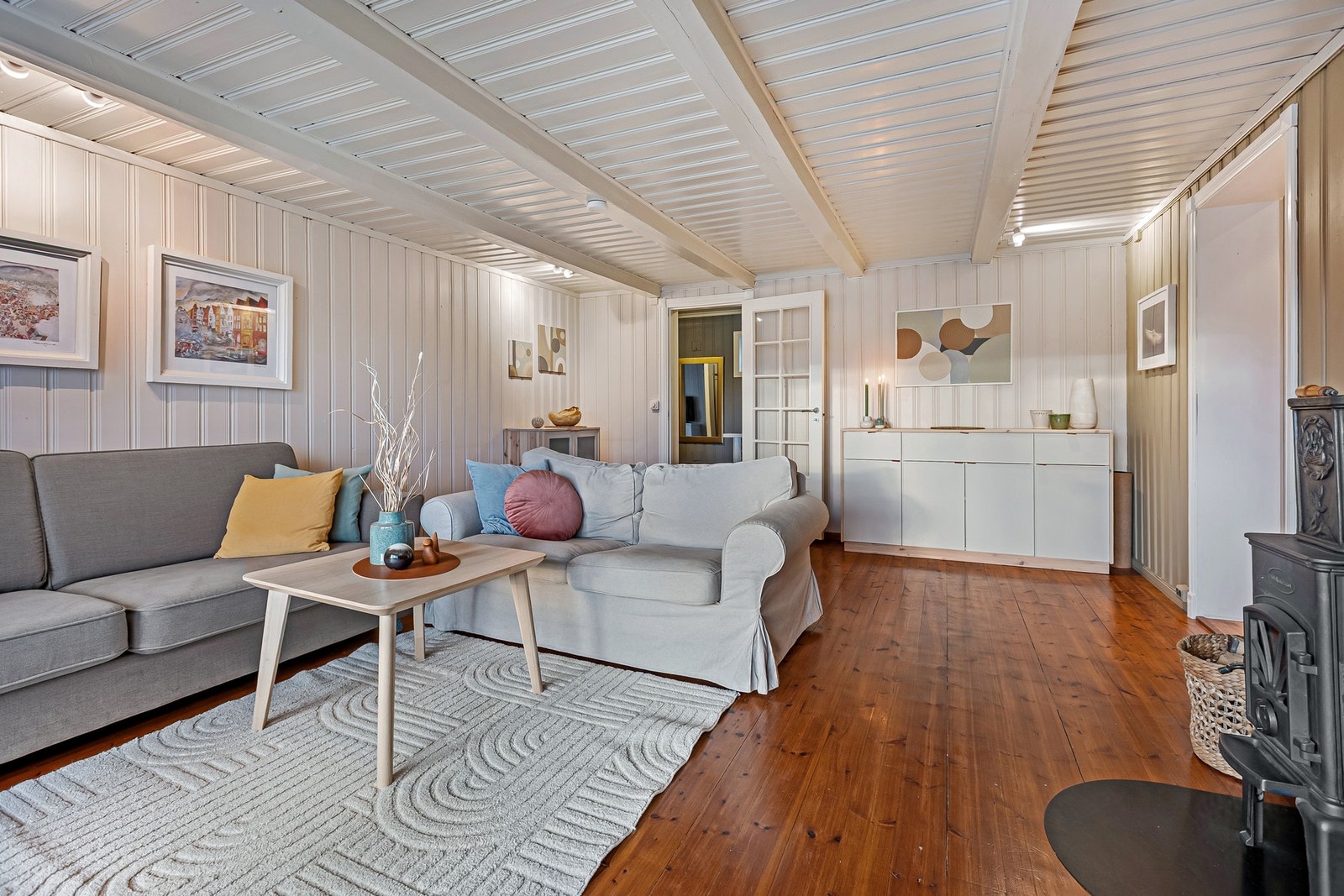 Stuen har lyse overflater og synlige bjelker i taket. Galleribilde