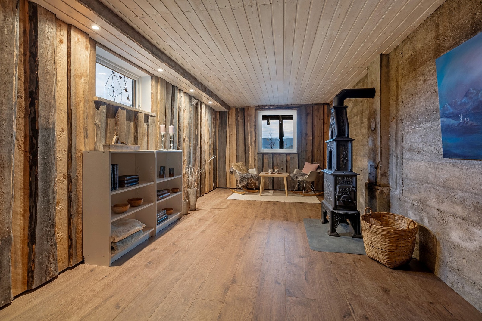 De grove trepanelene på veggene i kjellerstua og den vakre Ulefoss-ovnen skaper en varm og koselig atmosfære Galleribilde