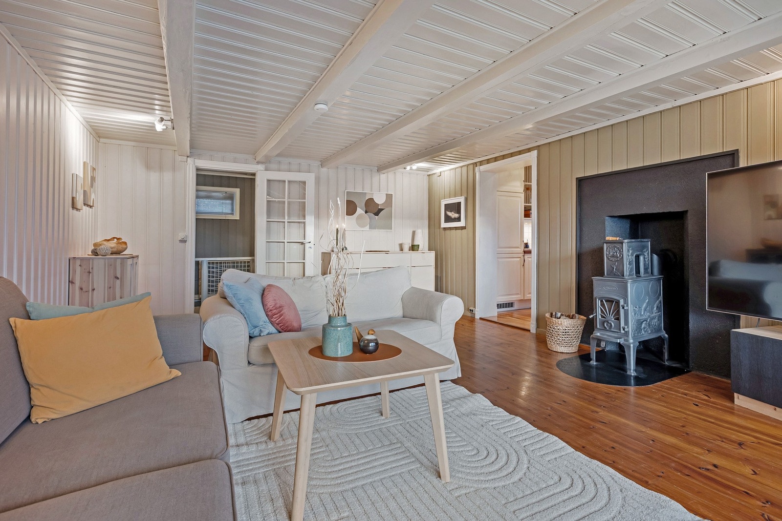 Stuen er romslig og gjennomført i lyse, tidsriktige fargetoner som harmonerer vakkert med de tregulvene. Galleribilde