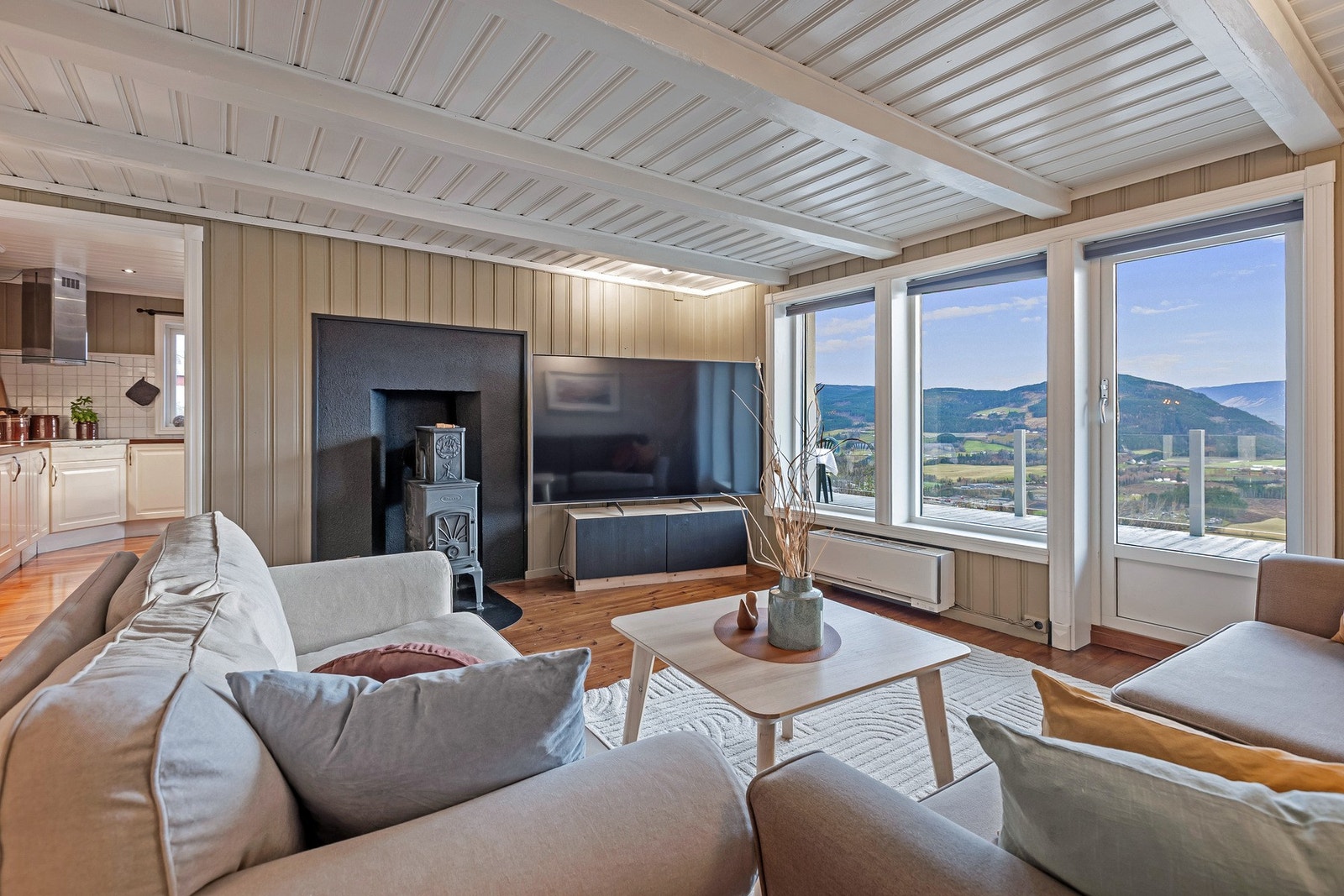 En flott vedovn skaper varme og stemning på kalde kvelder, og er plassert sentralt i rommet. Det er også varmepumpe i rommet. Galleribilde