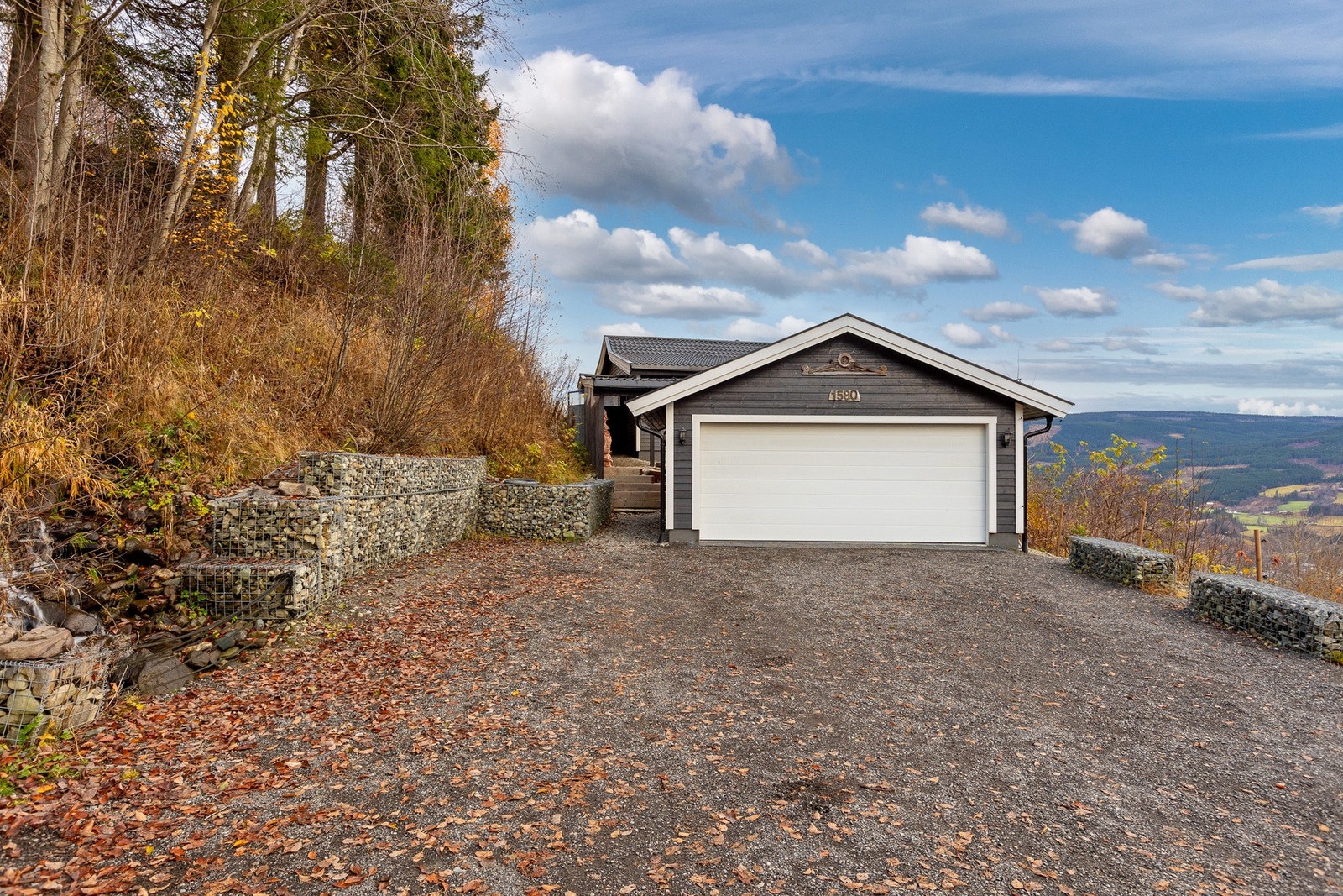 Gruset gårdsplass med god plass til parkering i tillegg til garasjen. Galleribilde