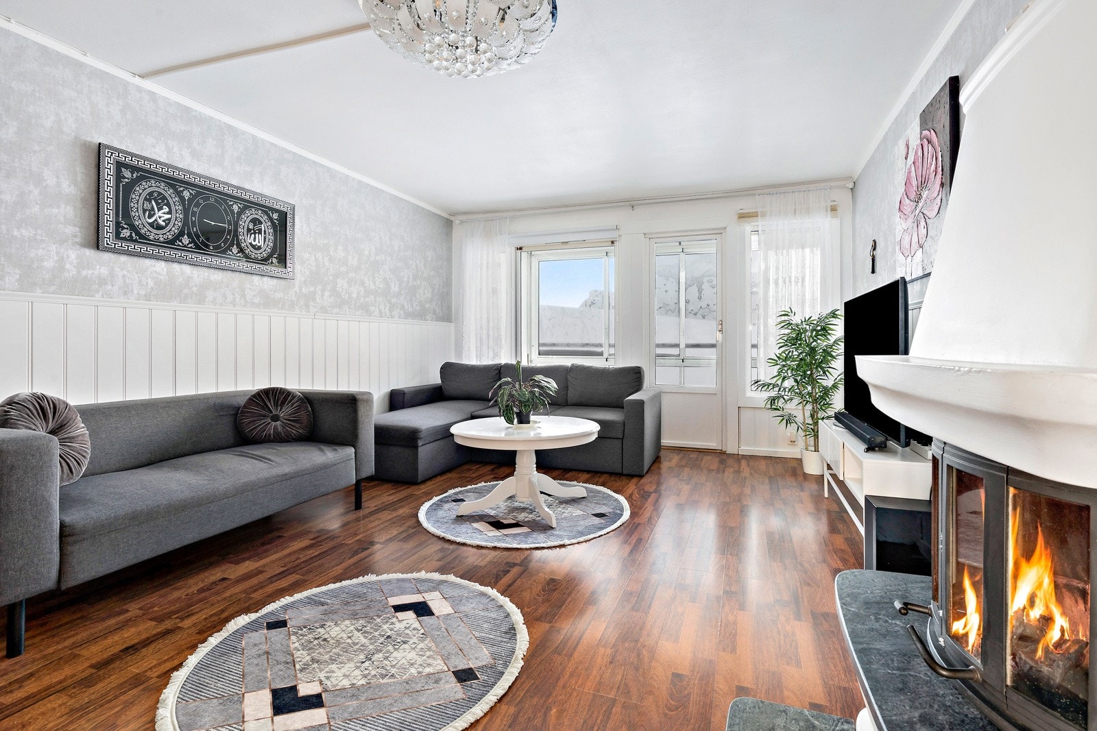 Stuen har peisovn, plass til spisebord og utgang til balkong Galleribilde