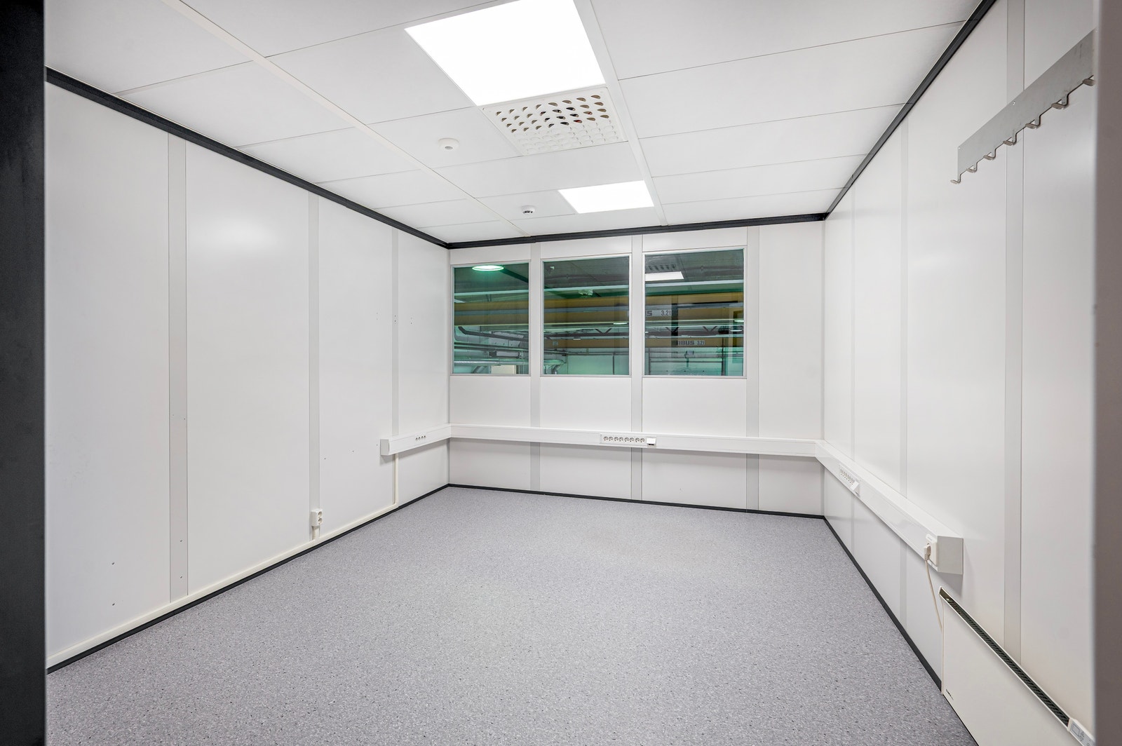 3 kontor på messaninetasje med vindu mot produksjon Galleribilde