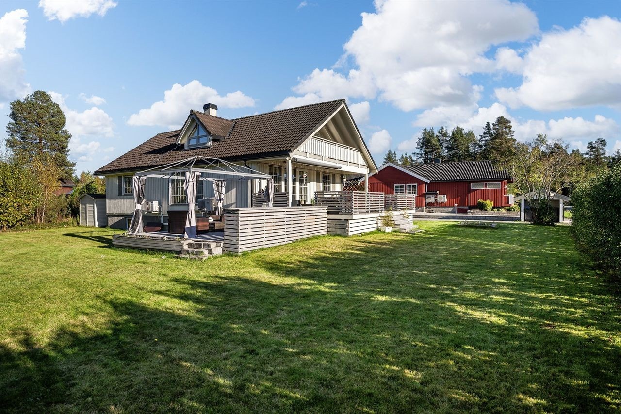 Den store hagen er pent opparbeidet med plen, hekk og diverse beplantning. Galleribilde