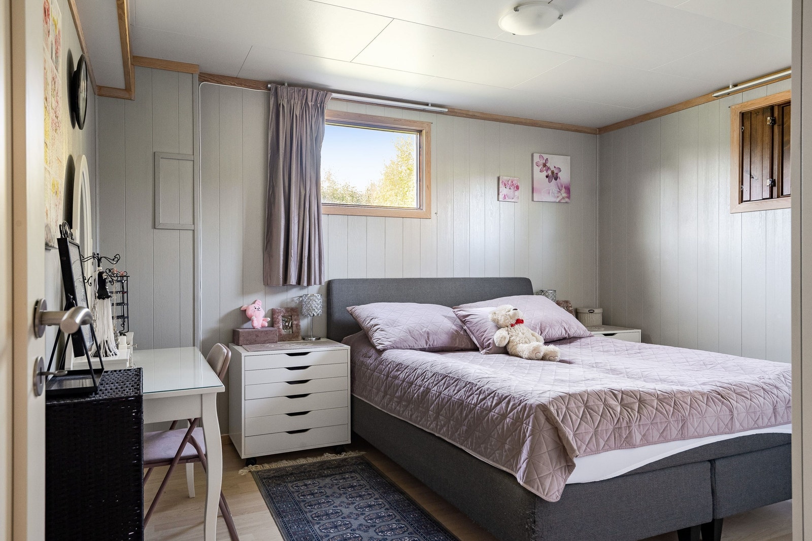 Første etasje inneholder et romslig soverom med laminatgulv og panel på veggene. Galleribilde